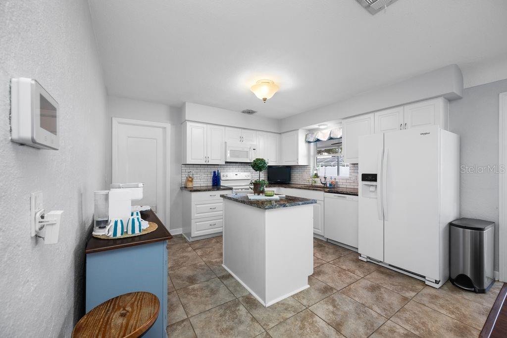 Plenty of cabinetry and cooking island - Showing door to the garage