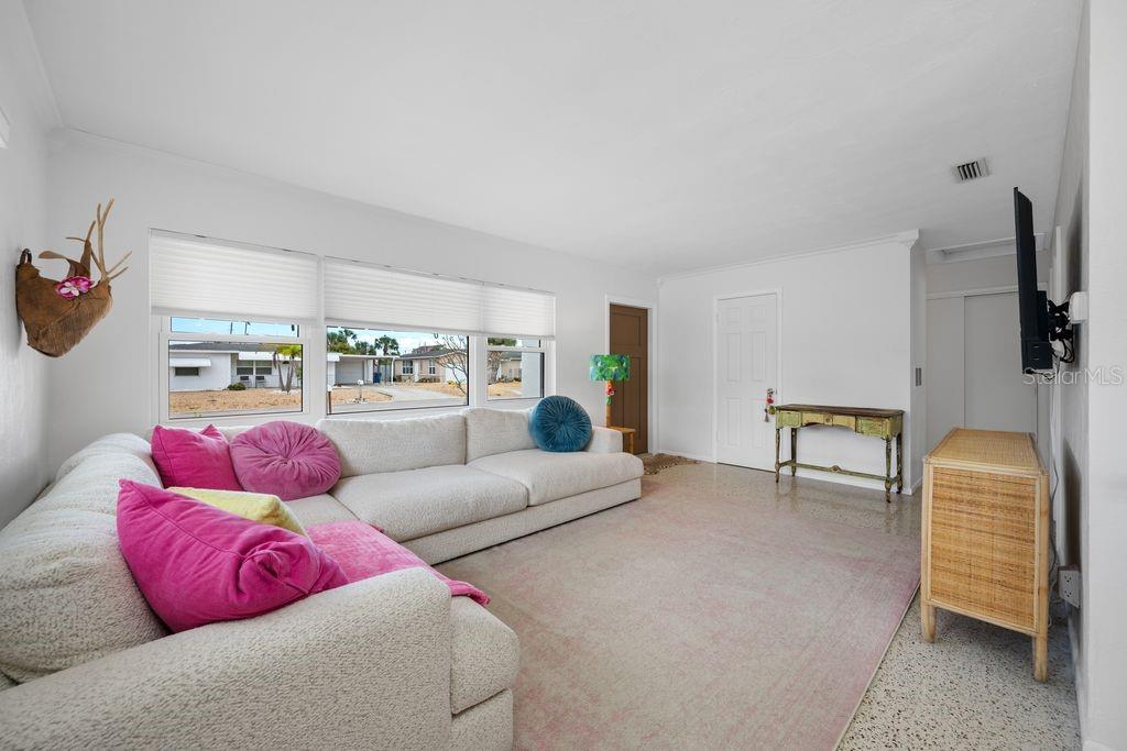 View from Corner of the Living Room to Front Entrance - Large Picture Windows (Impact-Installed 2019) - Front Entry Door (Impact-Installed 2025)  and Hallway is to the Right
