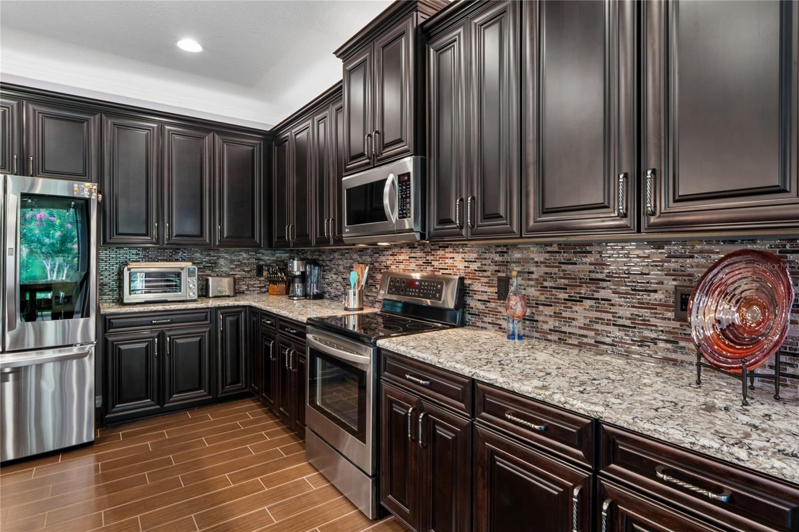Lush Dark Cabinetry with Solid Counters and Decorative Backsplash