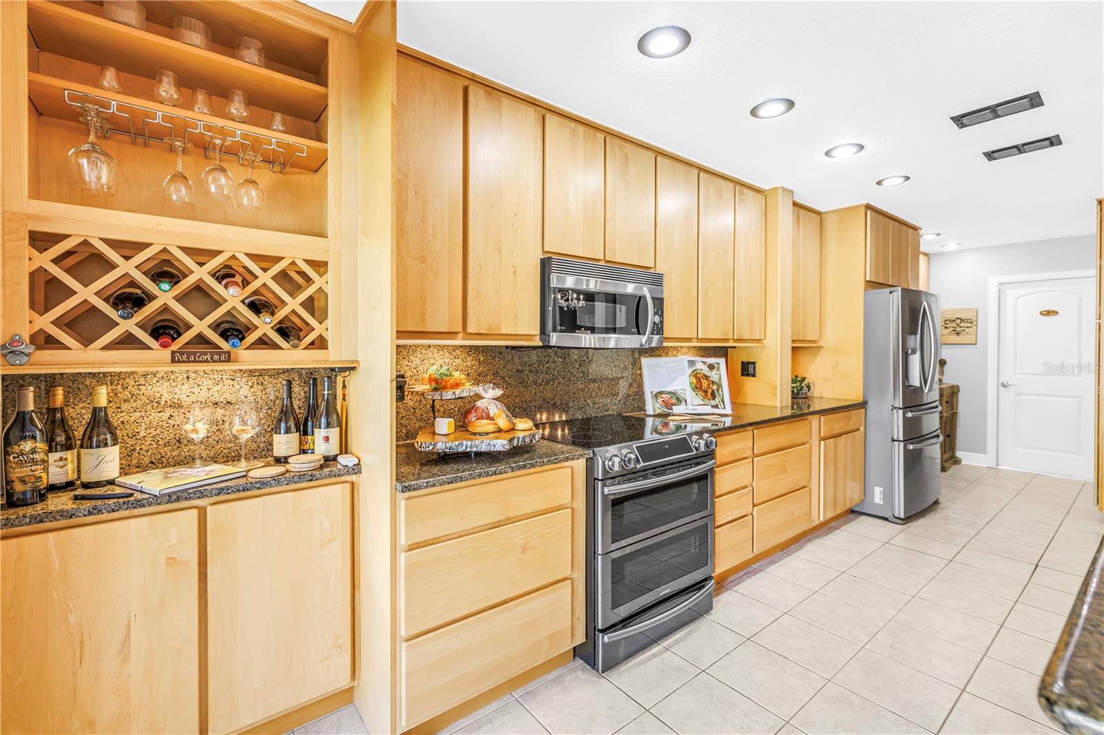 Wine Storage and Bar Service. New Dual Oven Range 2025, Custom Solid Wood Cabinetry and Granite Counters.