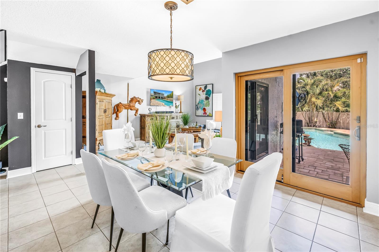 Spacious Dining with a view of the sparkling pool and outdoor lighting.