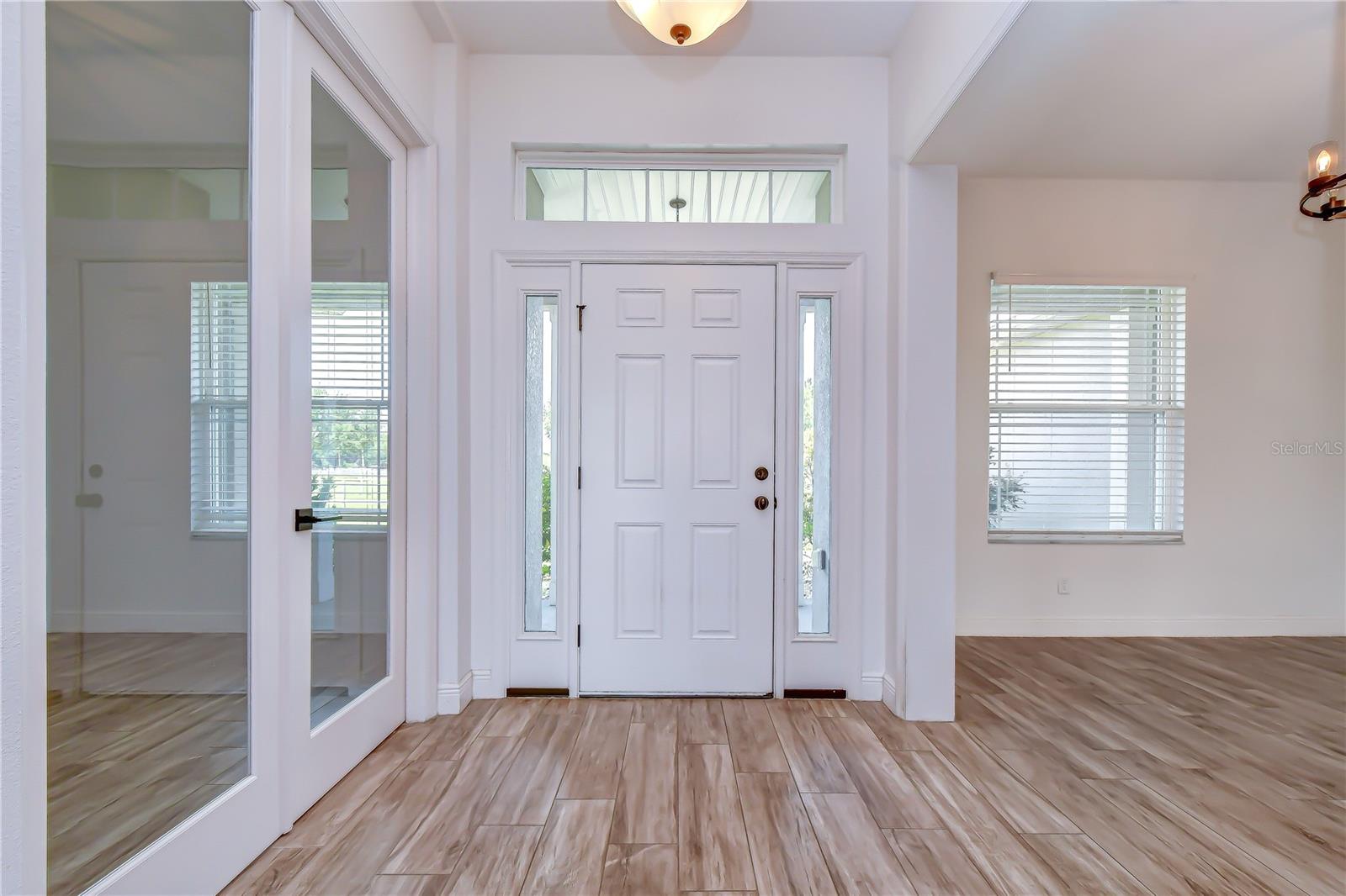 Bright and welcoming entry with soaring ceilings and neutral finishes.