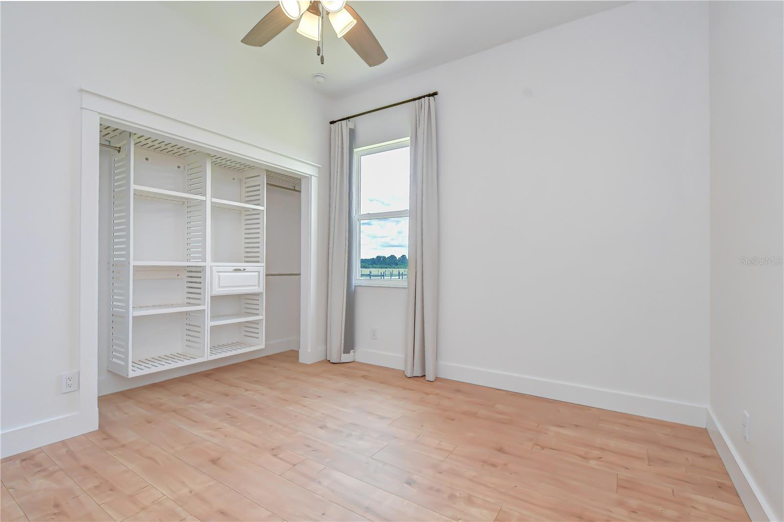 Spacious guest or family bedroom with custom closet system.