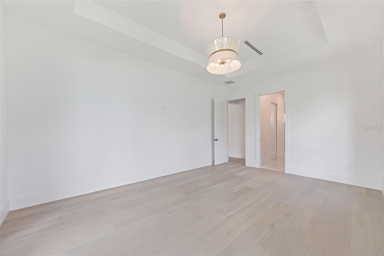 The luxurious primary suite offers a spa-inspired retreat featuring a freestanding soaking tub, oversized walk-in shower with rain head and handheld shower, premium Italian tile, designer fixtures, and thoughtful custom details throughout.