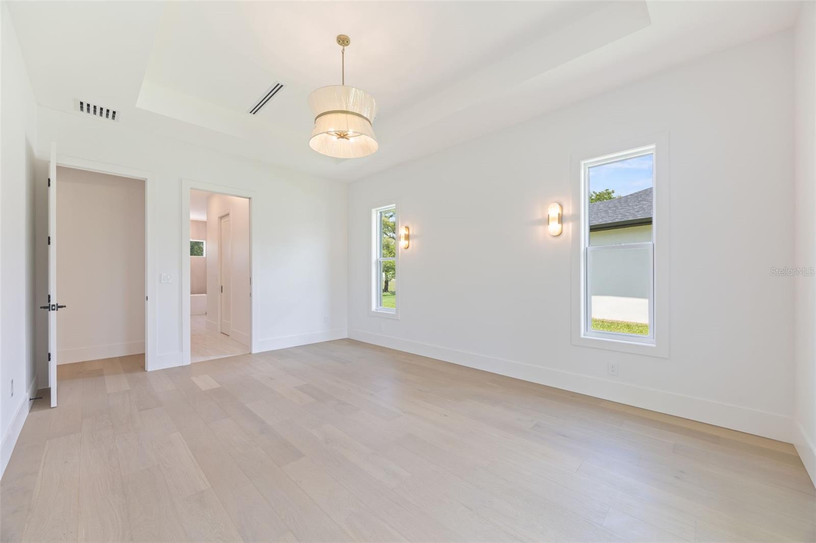 The luxurious primary suite offers a spa-inspired retreat featuring a freestanding soaking tub, oversized walk-in shower with rain head and handheld shower, premium Italian tile, designer fixtures, and thoughtful custom details throughout.