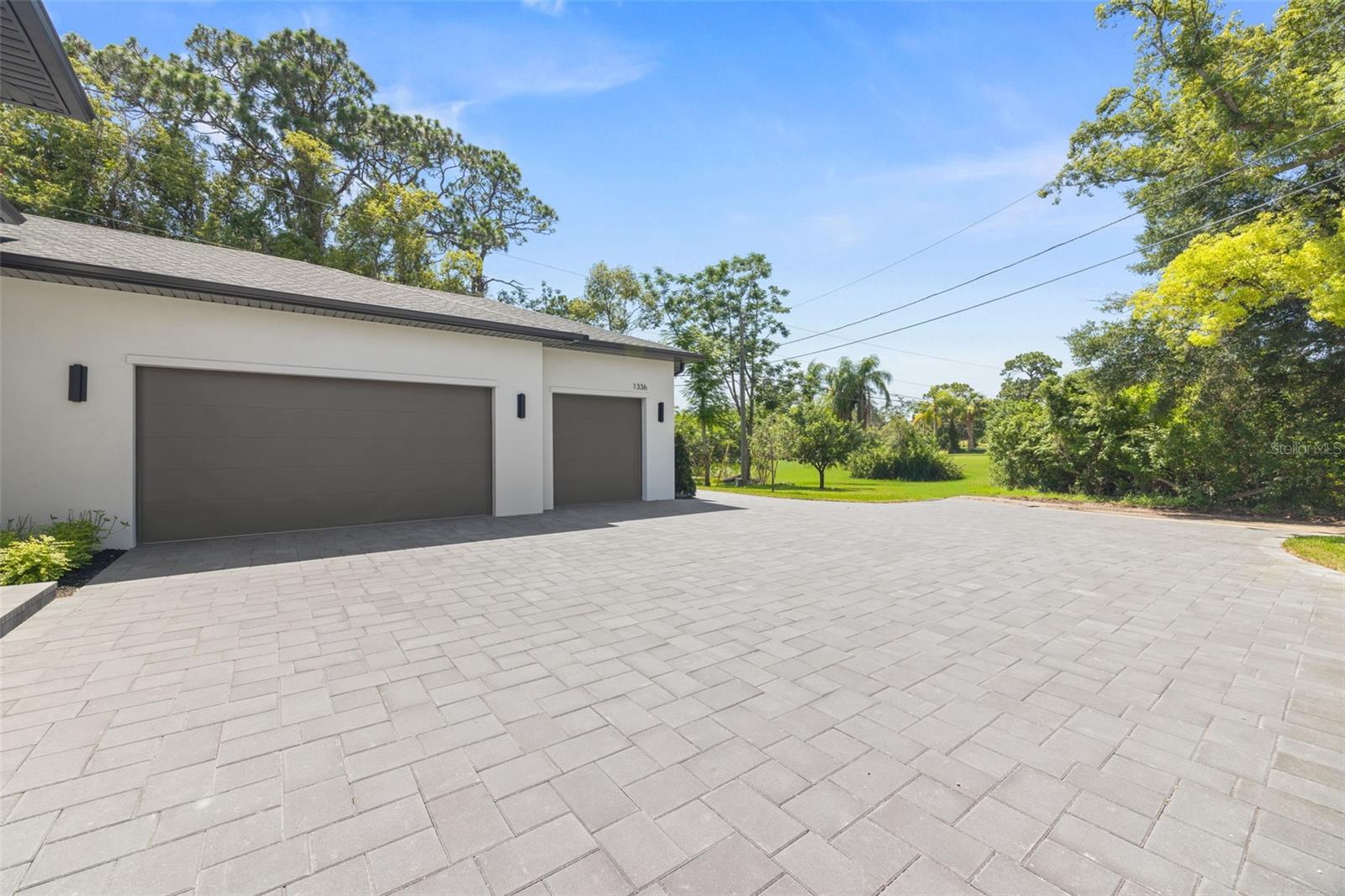 Modern paver driveway with turnaround area and additional parking space.
