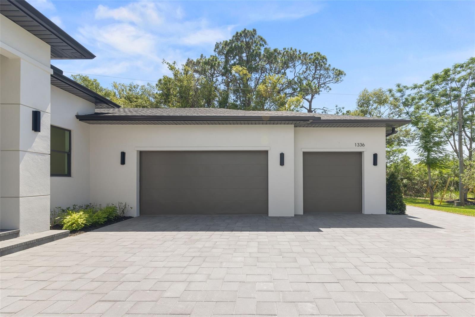 Modern paver driveway with turnaround area and additional parking space.