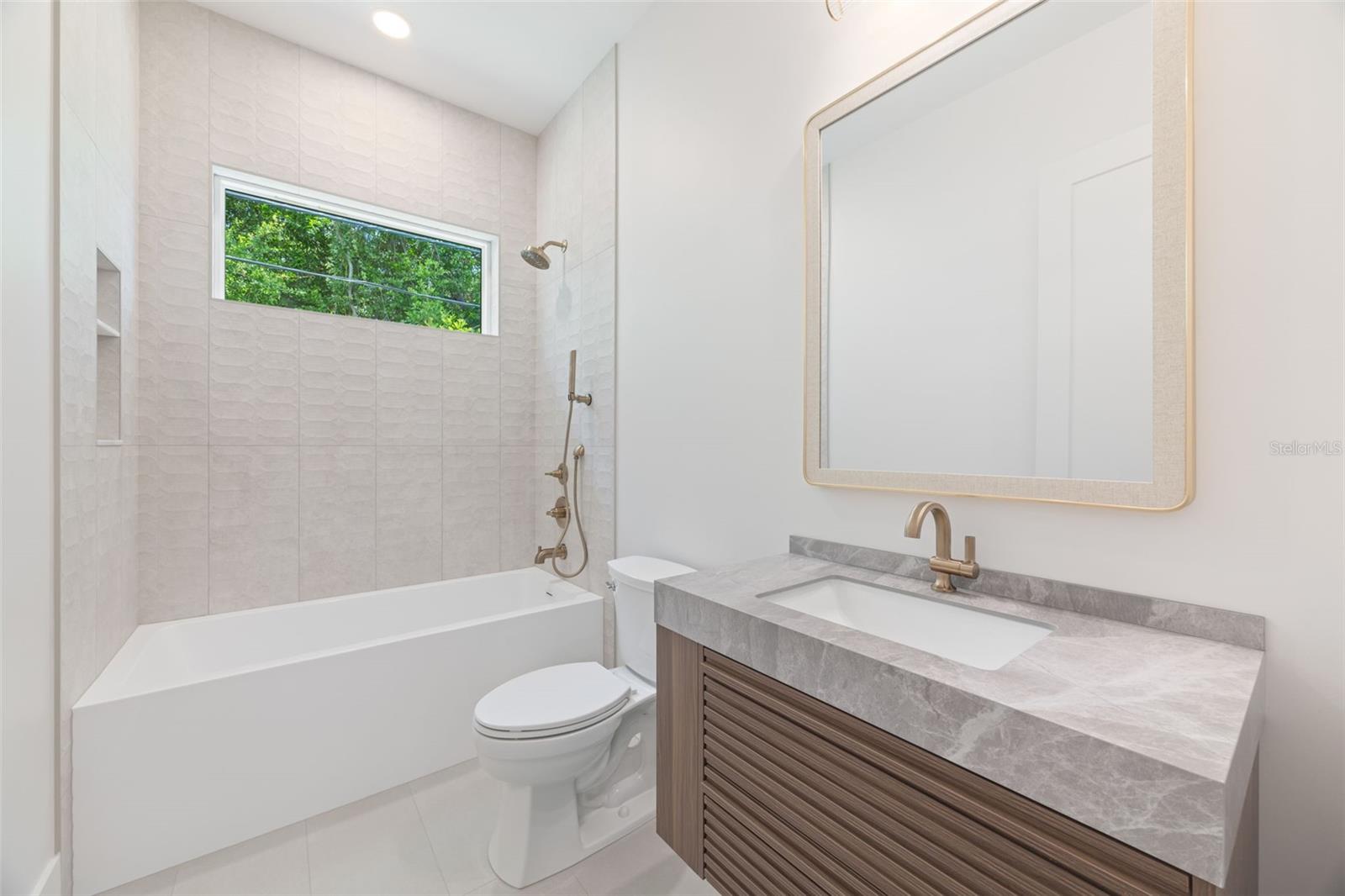 The 2nd full bathroom showcases oversized Italian tile, designer-selected fixtures, and elegant finishes consistent with the home's custom craftsmanship.