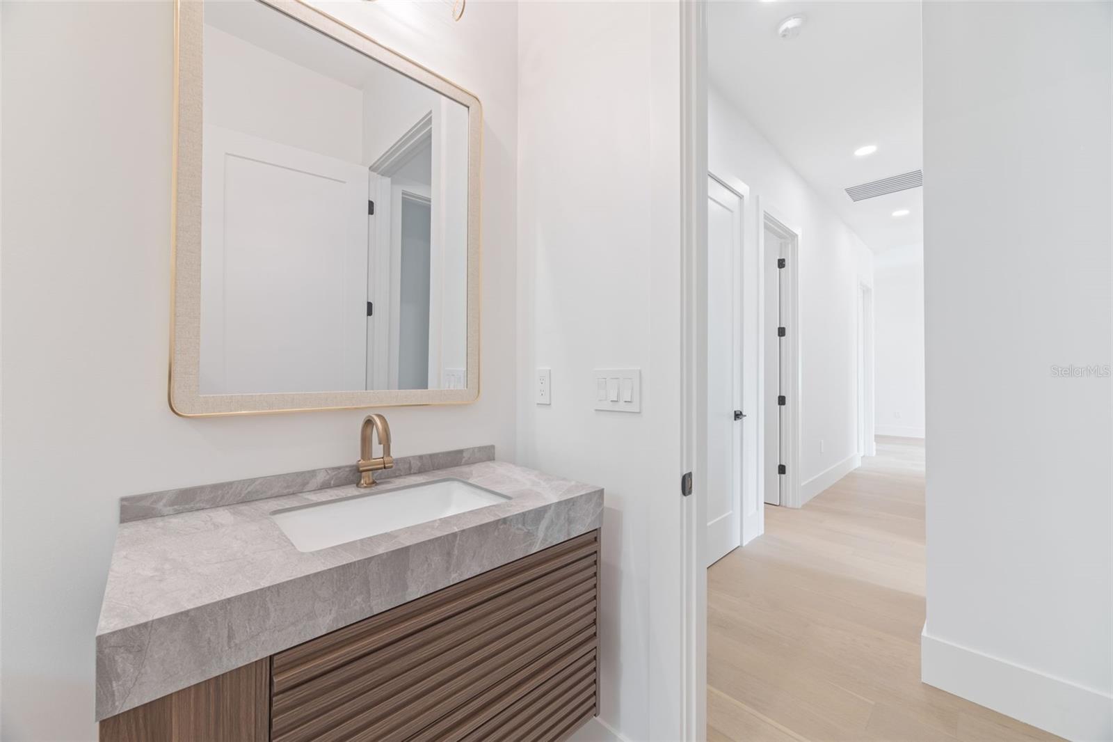 The 2nd full bathroom showcases oversized Italian tile, designer-selected fixtures, and elegant finishes consistent with the home's custom craftsmanship.