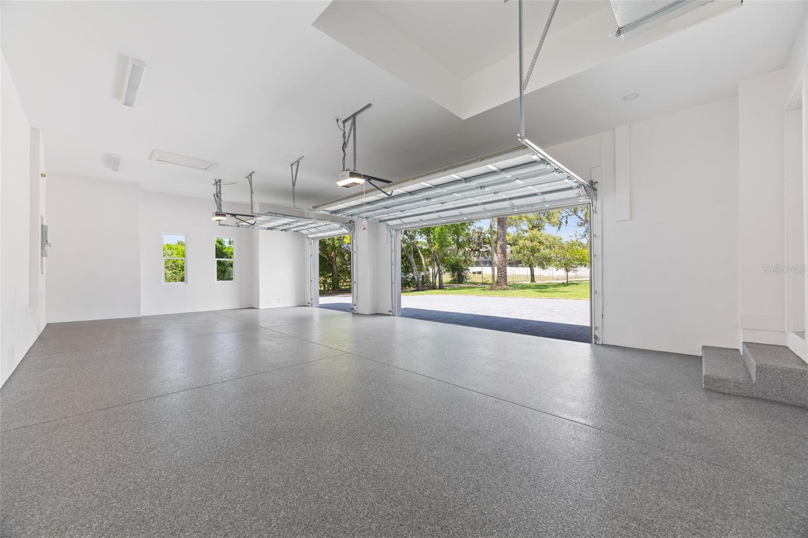 Oversized 3-car garage with industrial-grade epoxy flooring, Wi-Fi garage door openers, and impressive 11-foot ceilings.