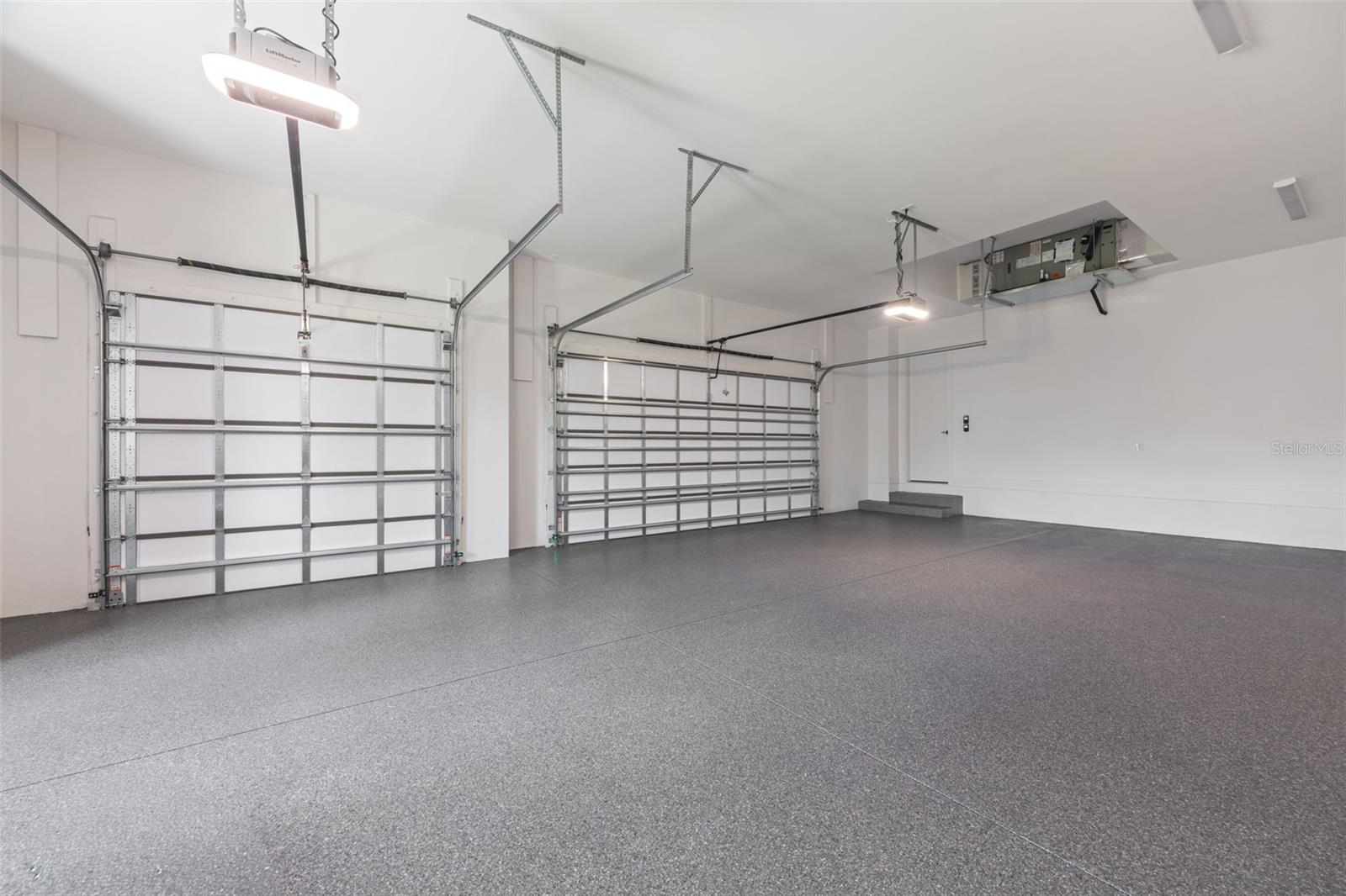 Oversized 3-car garage with industrial-grade epoxy flooring, Wi-Fi garage door openers, and impressive 11-foot ceilings.
