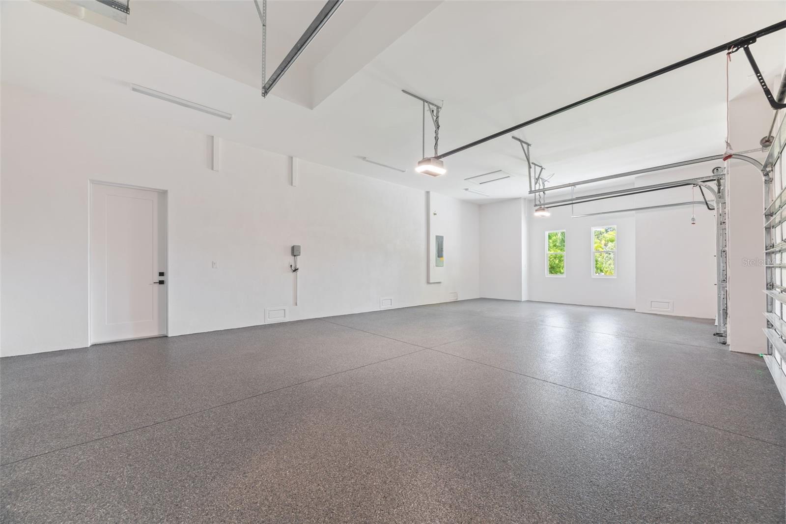 Oversized 3-car garage with industrial-grade epoxy flooring, Wi-Fi garage door openers, and impressive 11-foot ceilings.