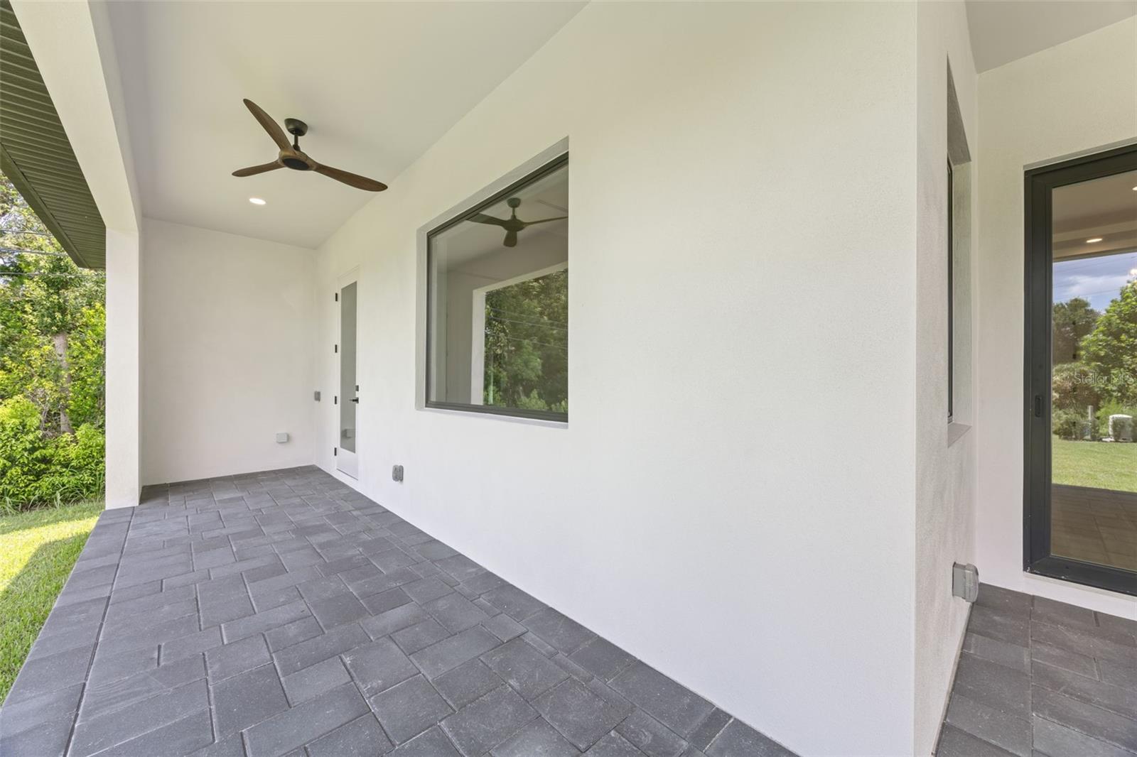 Covered paver lanai, pre-plumbed for a future outdoor kitchen, overlooking the beautifully landscaped yard with premium St. Augustine sod and mature native pine trees.