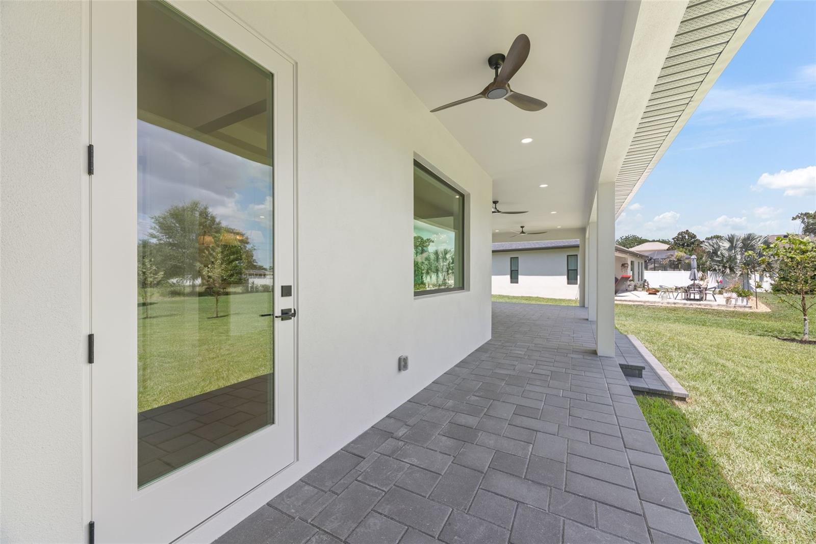 Covered paver lanai, pre-plumbed for a future outdoor kitchen, overlooking the beautifully landscaped yard with premium St. Augustine sod and mature native pine trees.