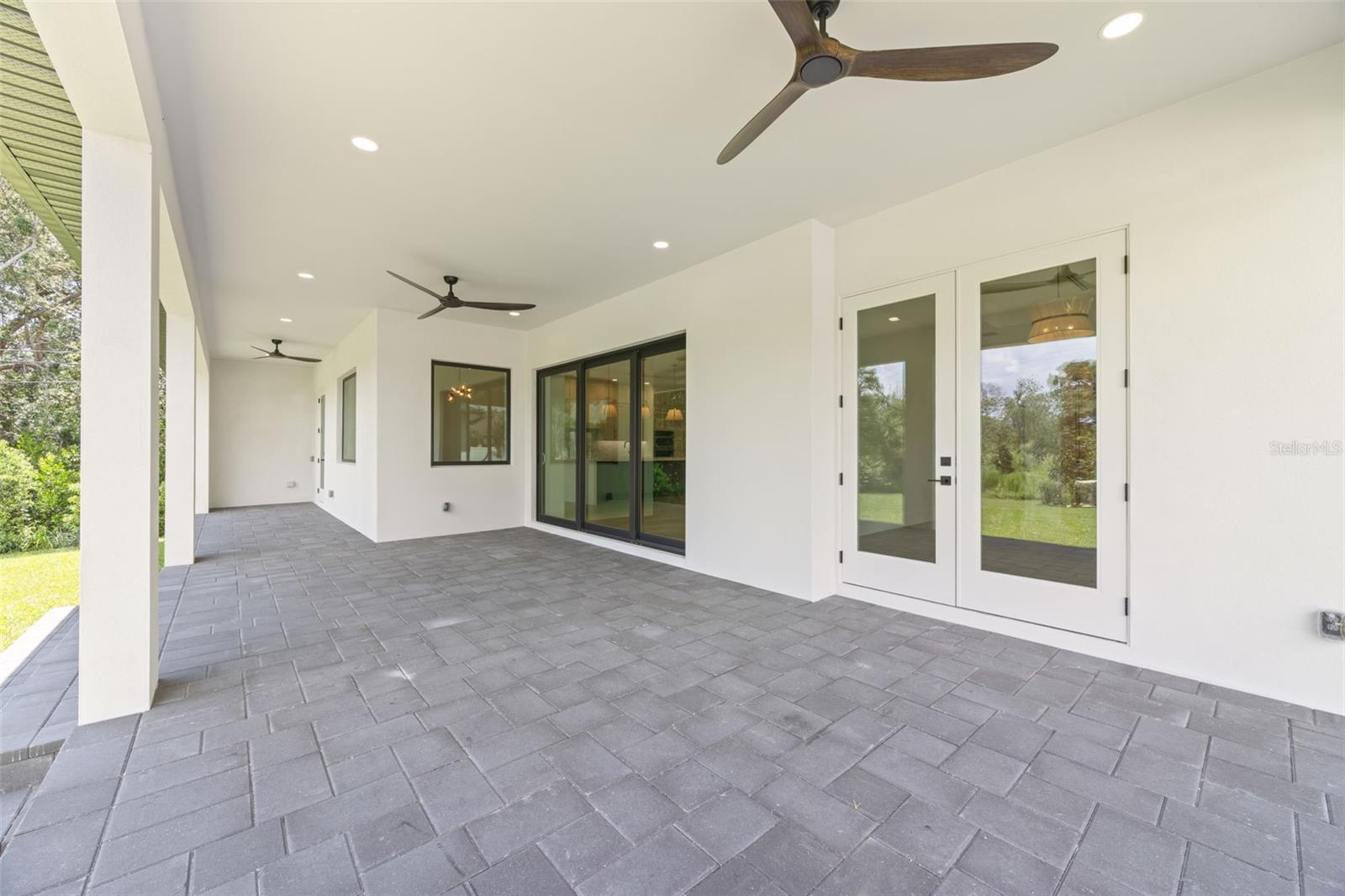 Covered paver lanai, pre-plumbed for a future outdoor kitchen, overlooking the beautifully landscaped yard with premium St. Augustine sod and mature native pine trees.