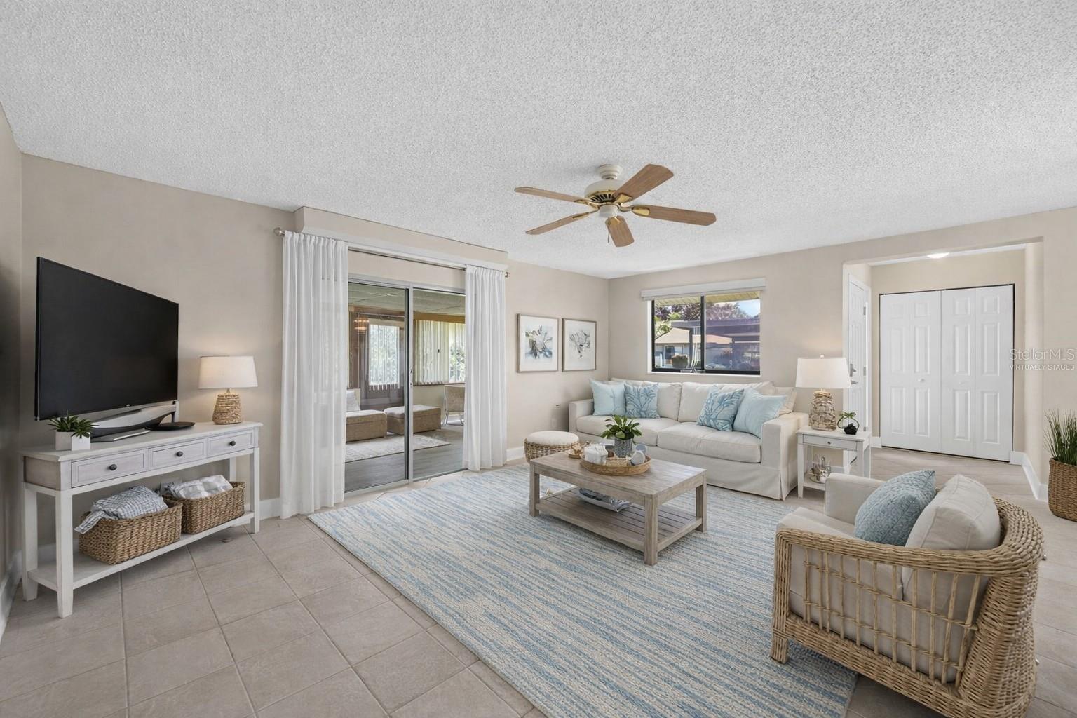 Virtually staged Living area with the adjoining outside enclosed porch area