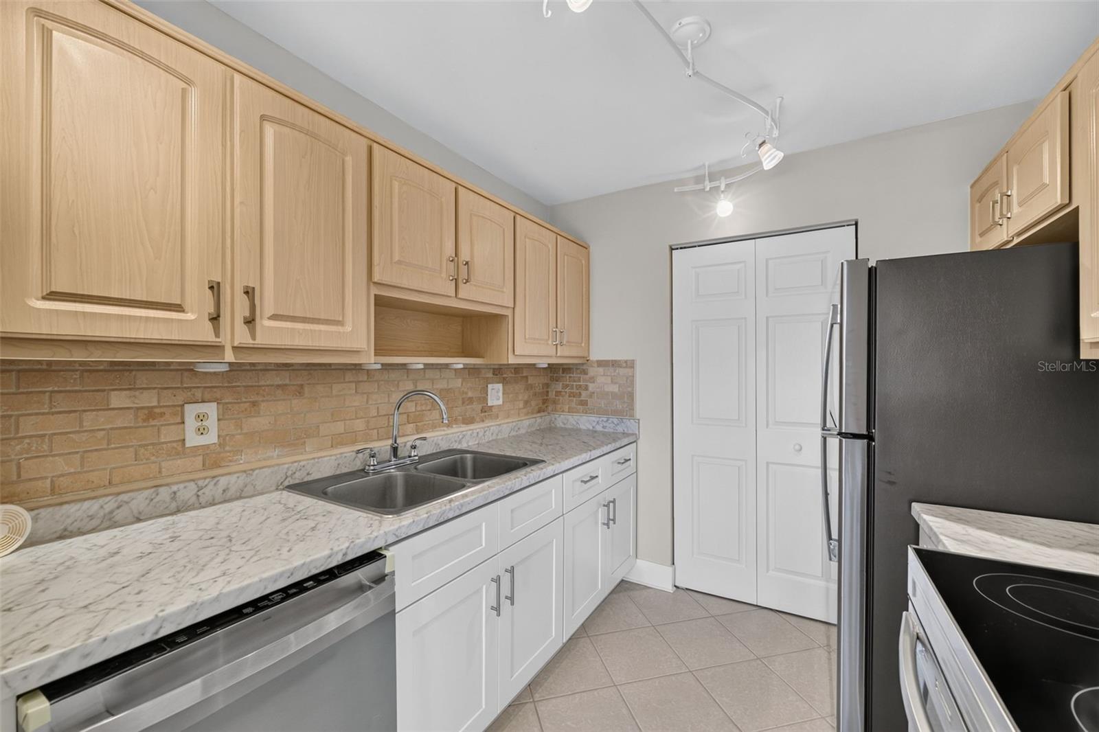 Kitchen area with two toned cabinets, all new applicances