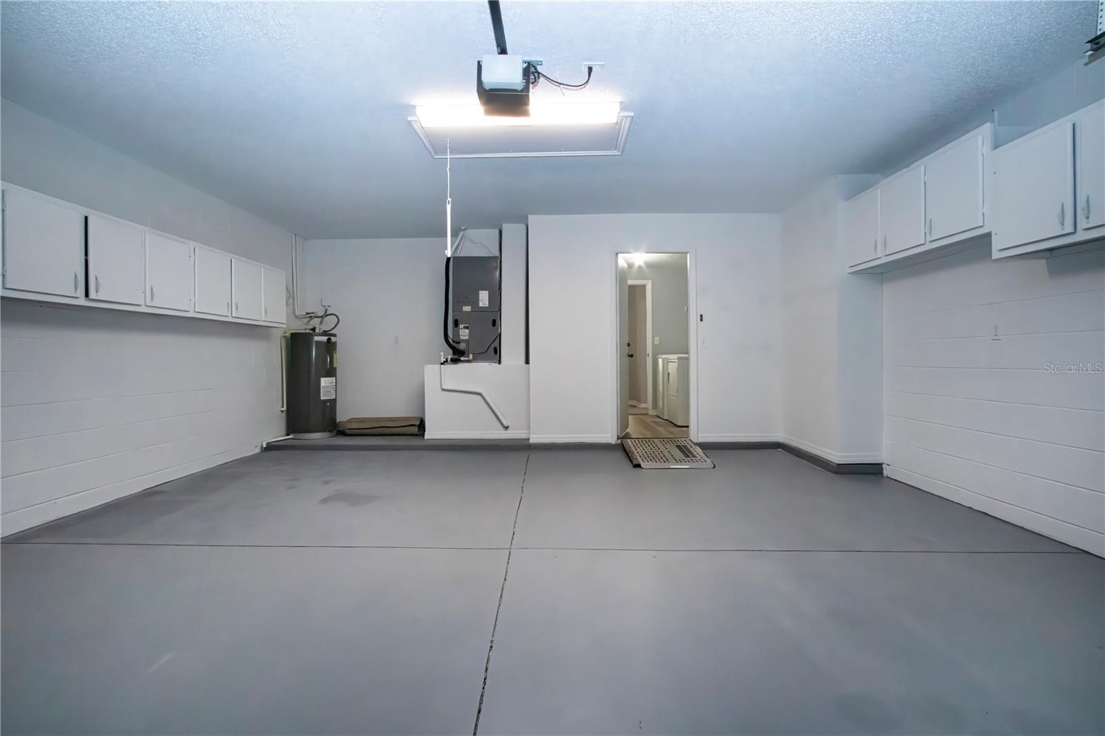 Spacious 2 car Garage w/storage cabinets & pull down ladder to attic