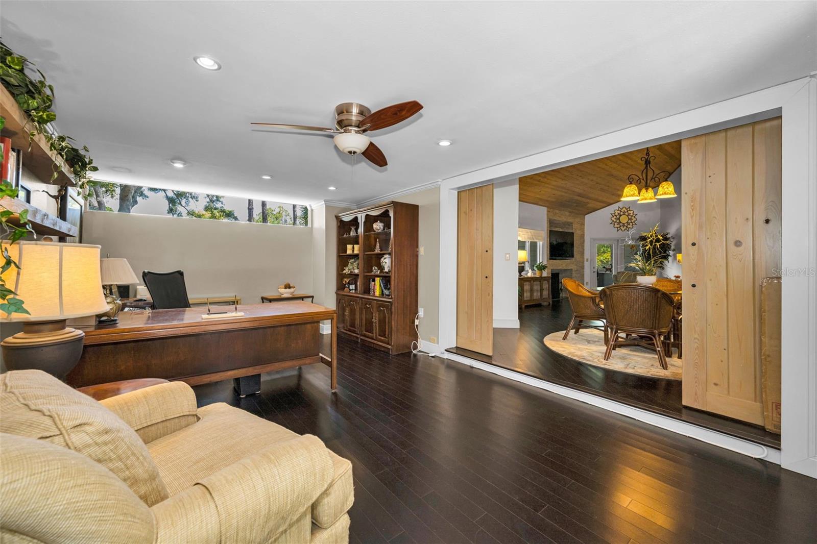 The spacious den, opens to the formal dining area and is next to the 2 car garage, see floor plan. Not all Arbors home have a den. This one has beautiful floors and great windows!