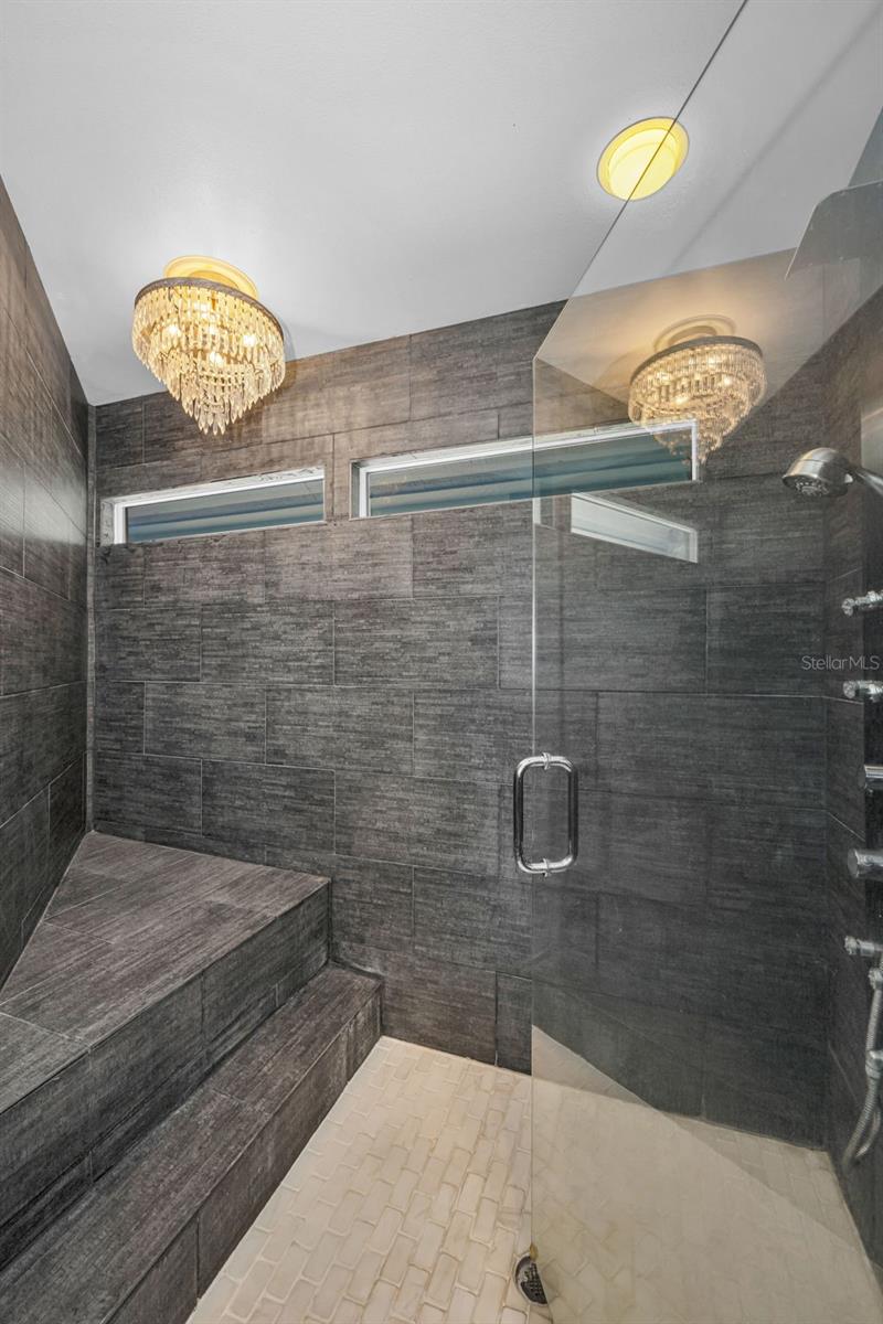 Master shower with bench and chandelier