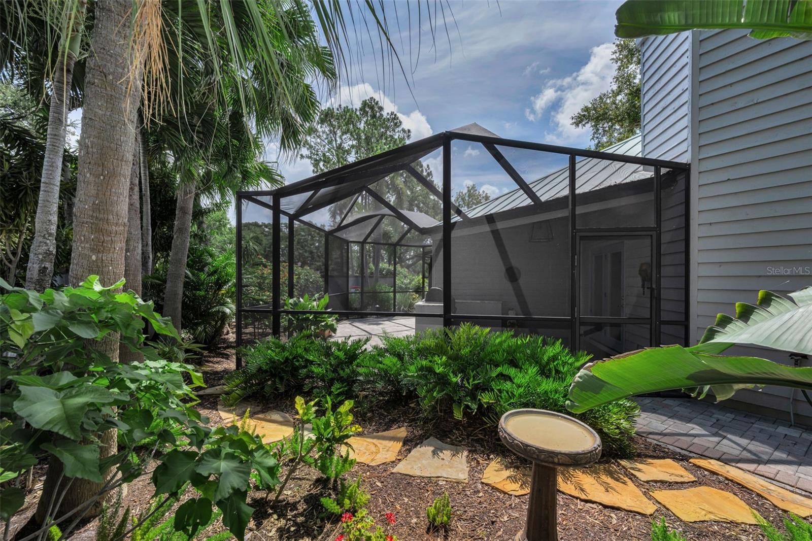 The screened patio area off the living room and wrapping around to the lovely pond. It has an outdoor grill and seating for many many guests!