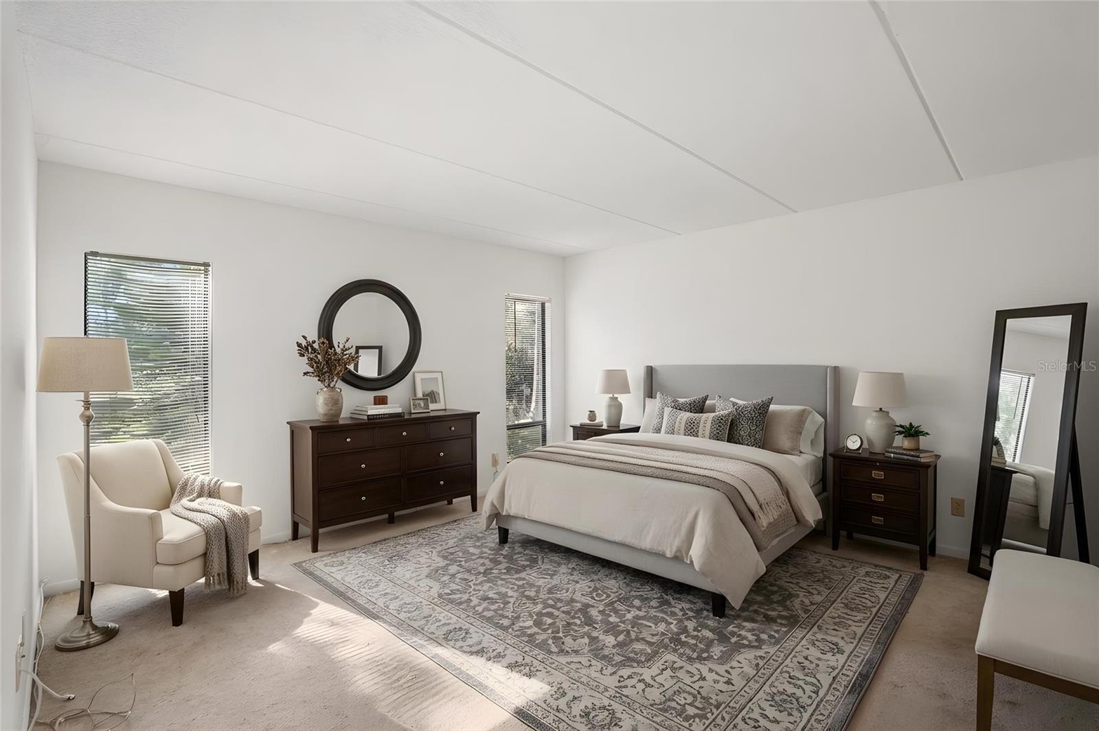 Spacious Primary Suite. Natural light and generous dimensions create a comfortable bedroom with plenty of room to arrange furniture to suit your style. Virtually stged photo.
