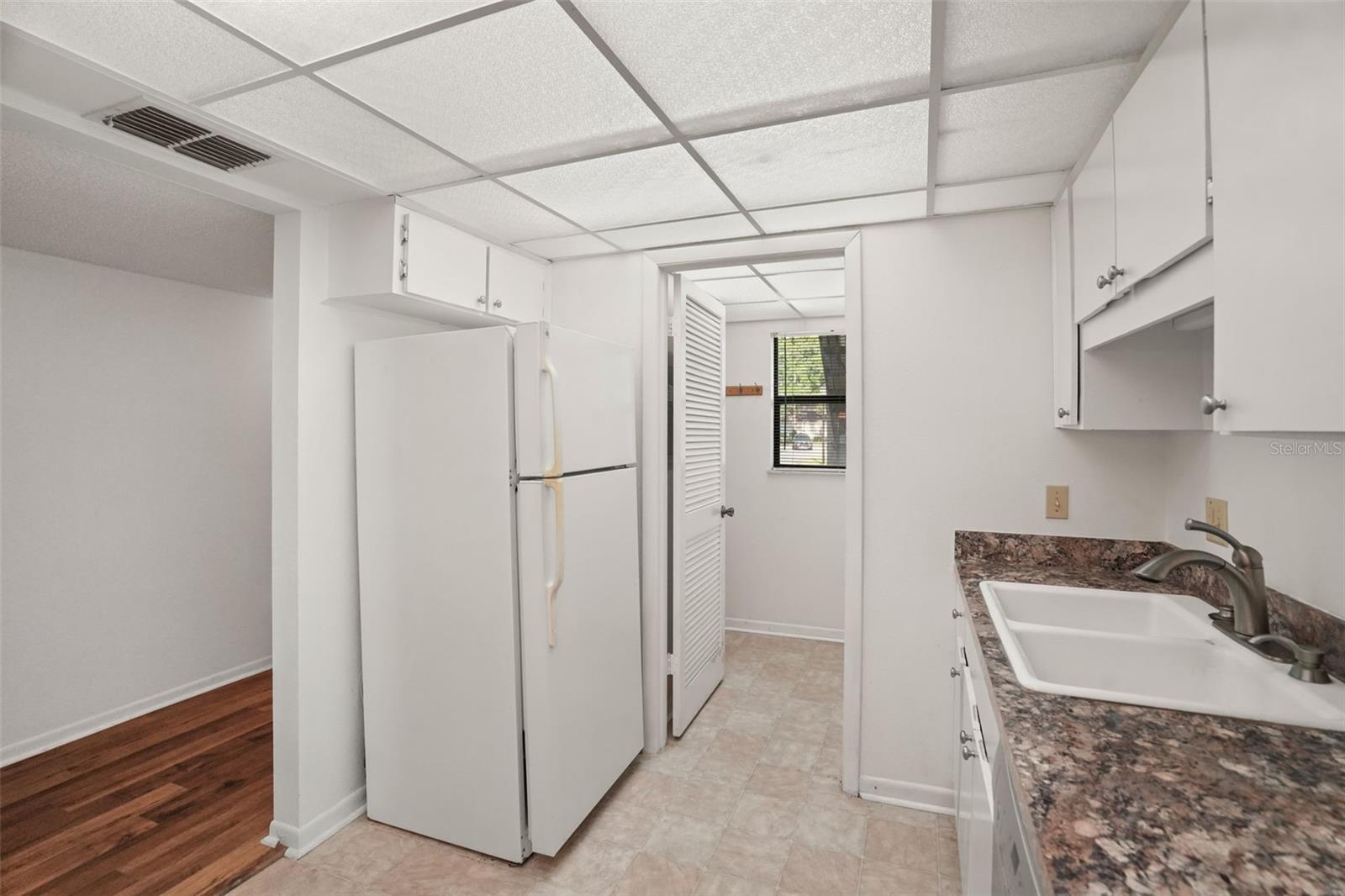 Function Comes First. The efficient galley kitchen offers generous workspace and easy access to a dedicated laundry room tucked just beyond.