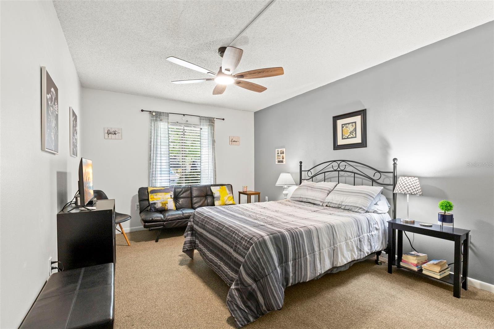 Soft neutral tones and natural light create a relaxing bedroom with plenty of space for additional furnishings.