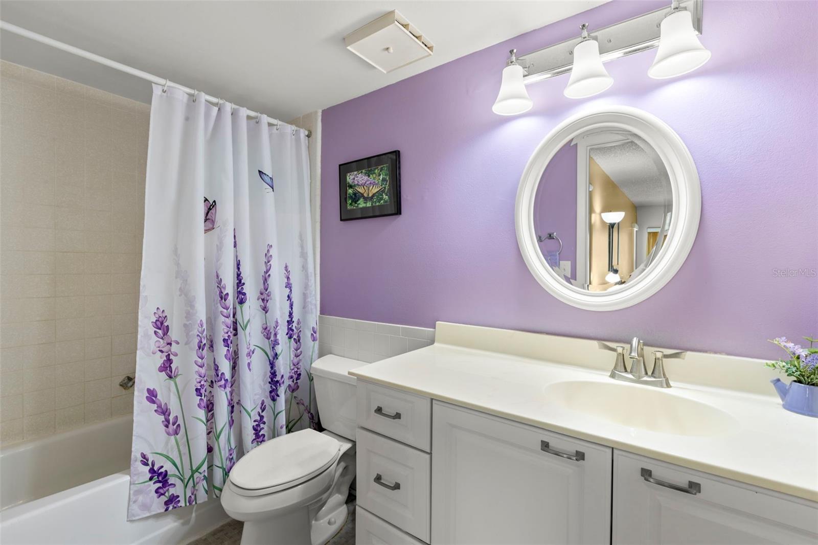 A spacious vanity provides generous counter space, complemented by a newer faucet and updated lighting.