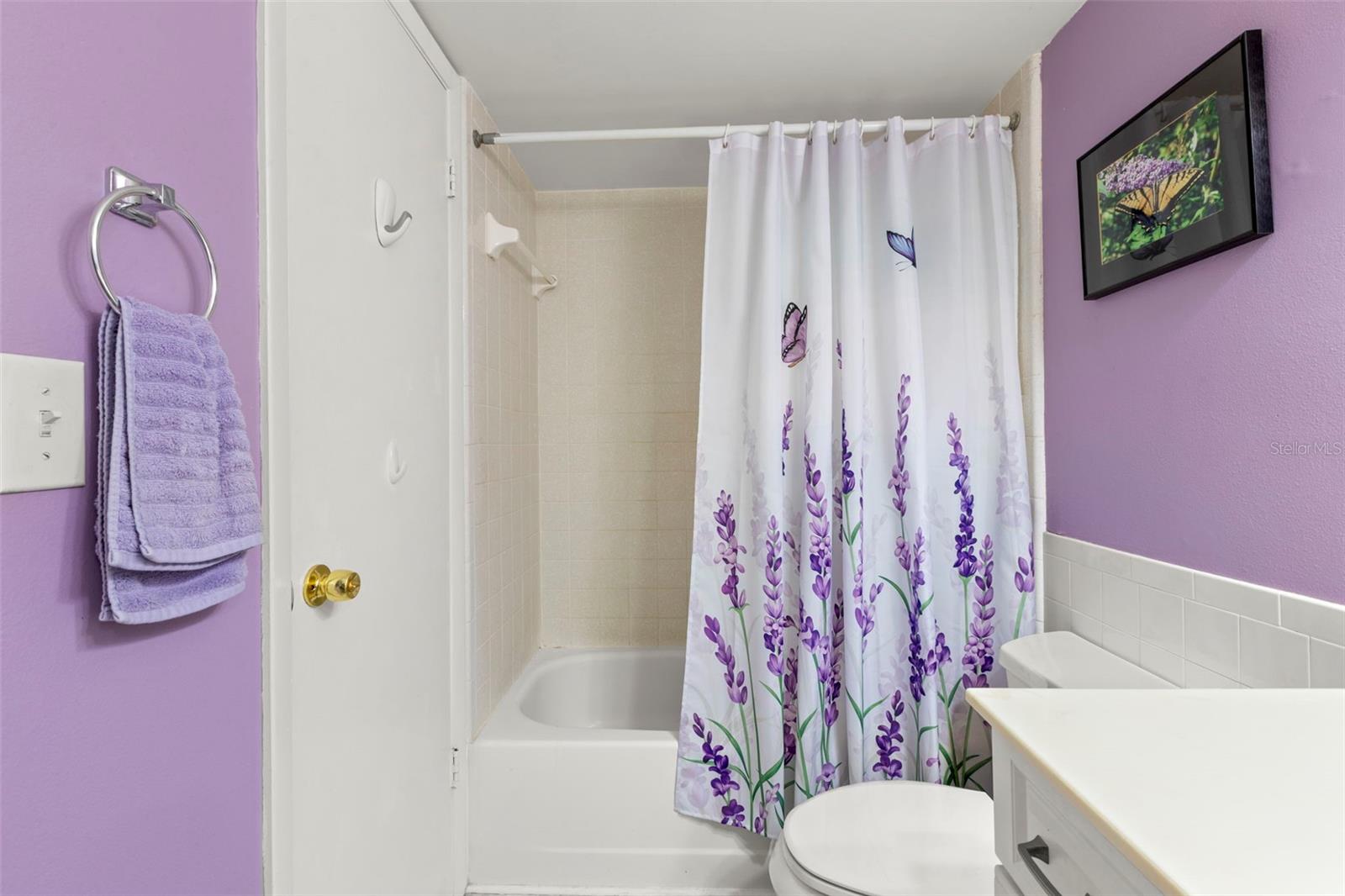 A tub and shower combination completes the bathroom.