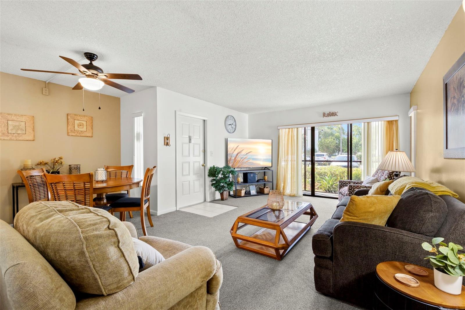 The open floor plan creates comfortable spaces for relaxing, dining, and entertaining, while large sliding glass doors fill the home with natural light.
