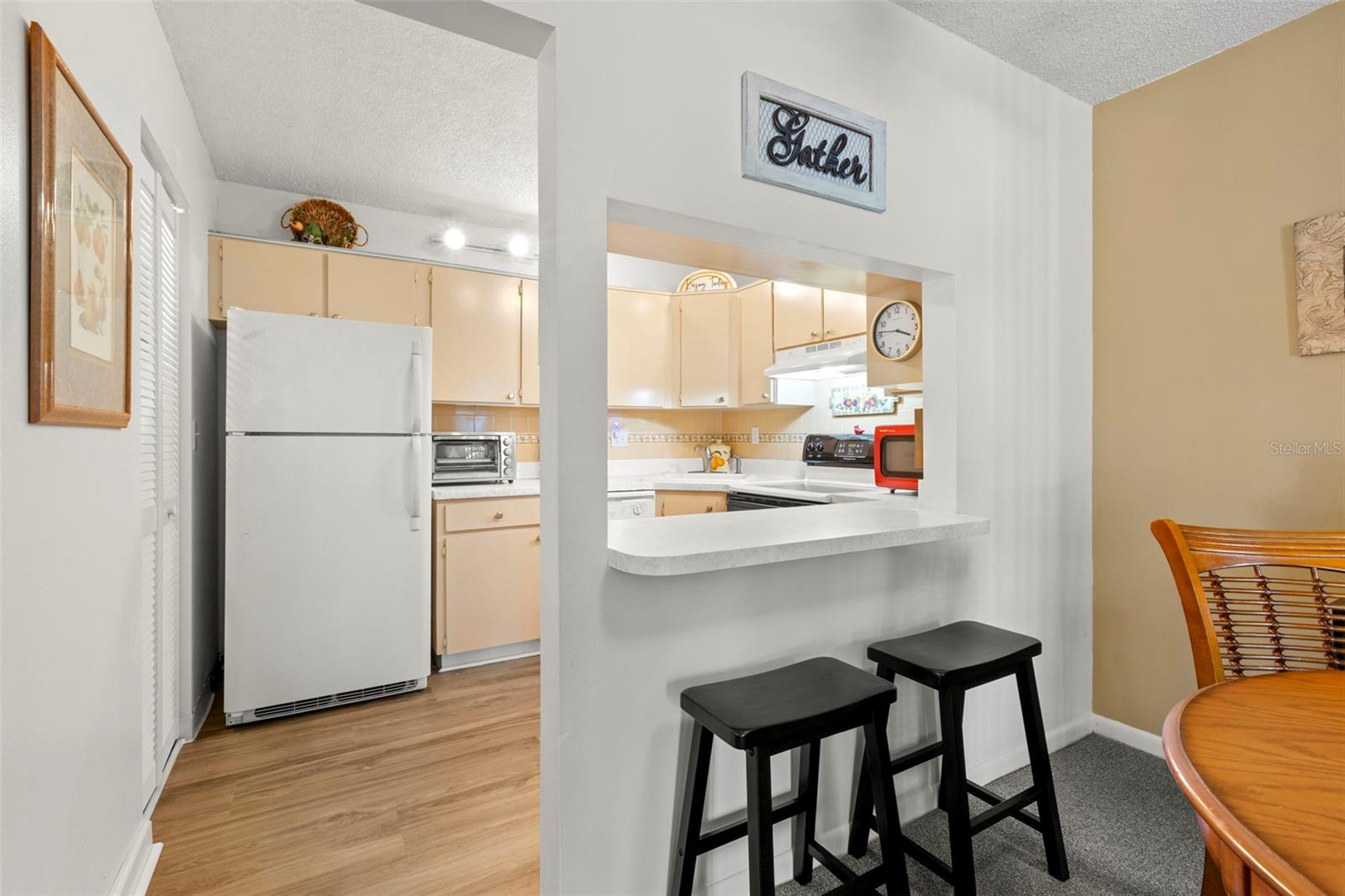 A breakfast bar opens the kitchen to the dining area, while wood-look laminate flooring adds warmth and easy maintenance.