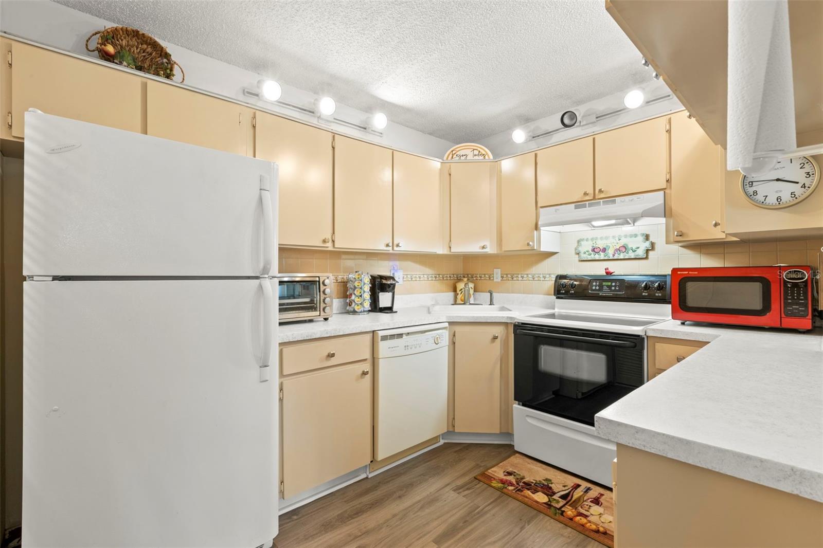 The U-shaped kitchen keeps everything within easy reach, with abundant cabinetry, ample prep space, and a convenient breakfast bar.