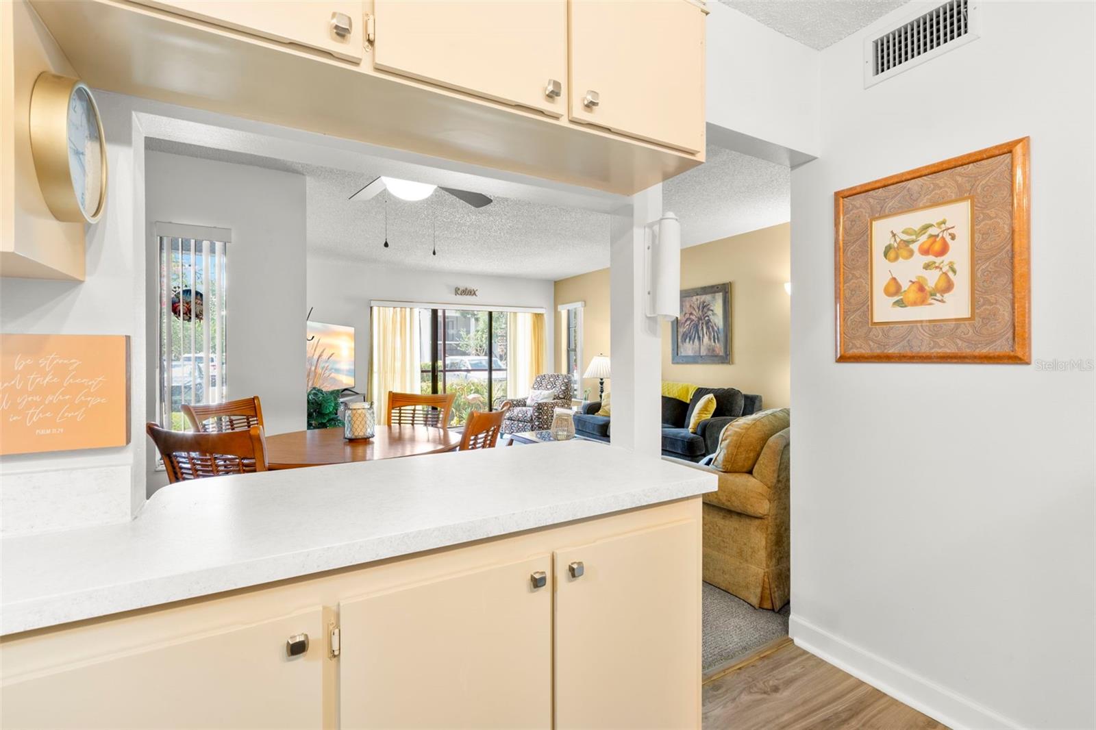 A wide pass-through and breakfast bar keep the kitchen connected to the dining and living areas, creating an open, inviting feel throughout the home.