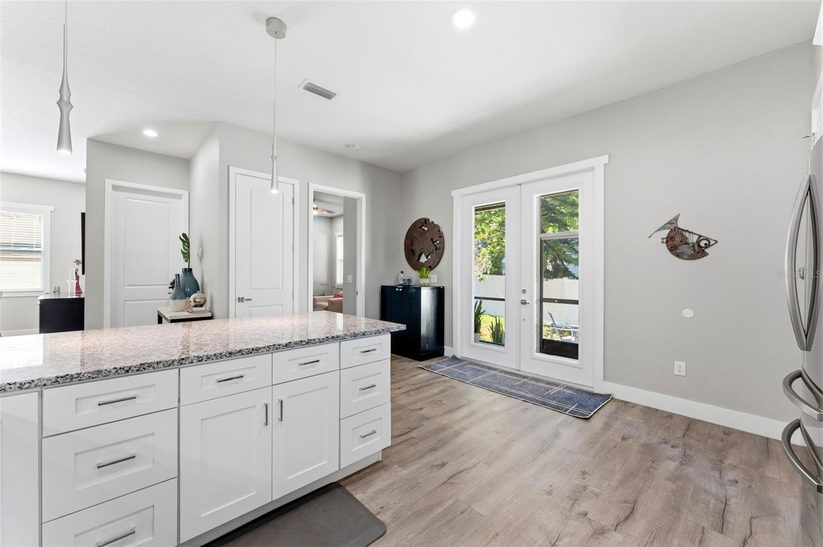 Open-concept kitchen with solid-wood cabinetry, granite countertops, stainless steel appliances, and custom lighting including under-counter kitchen lights.