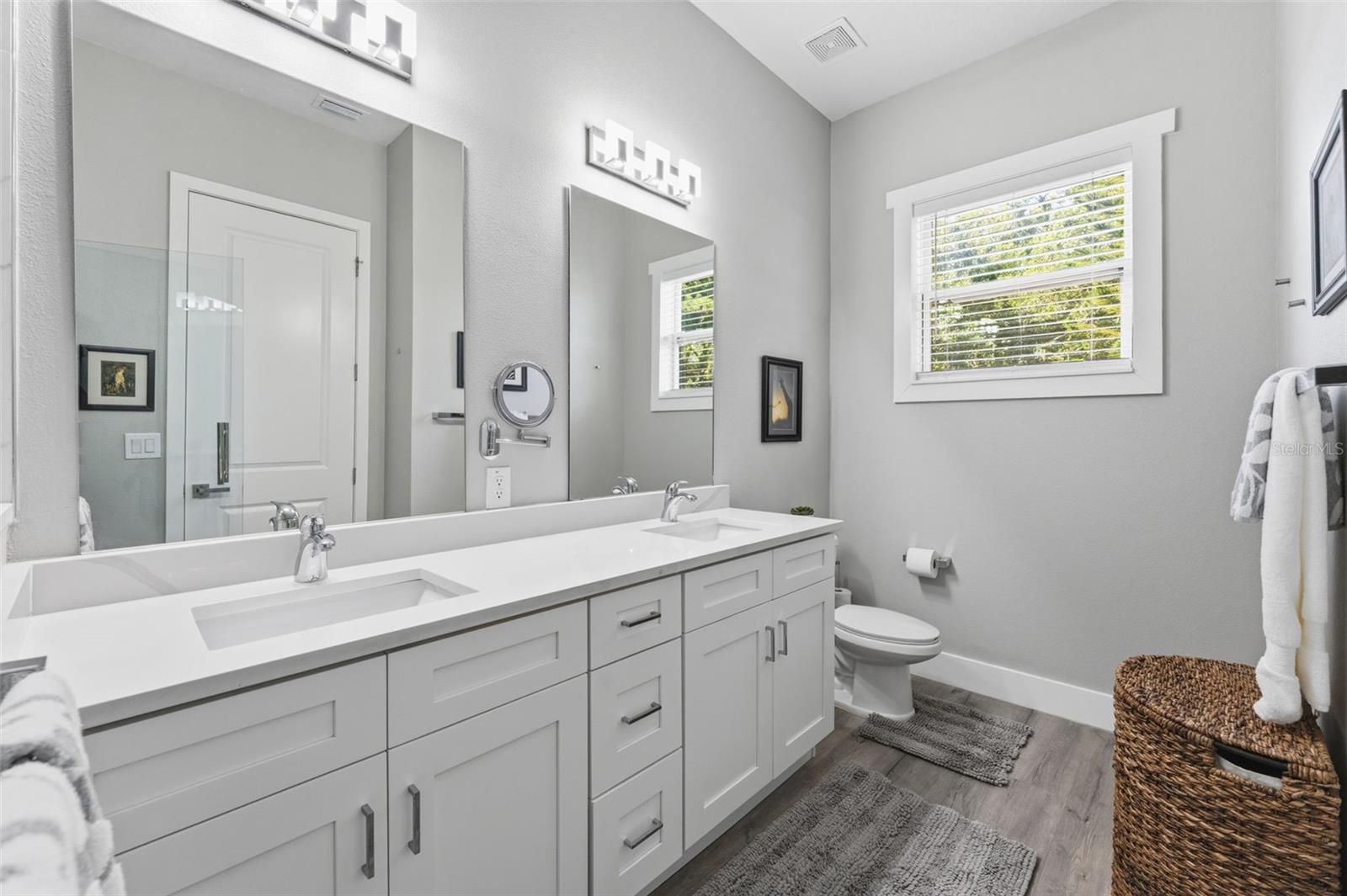Large Primary Ensuite Bathroom with a double vanity and a large walk-in shower with frameless glass door and rainfall showerhead