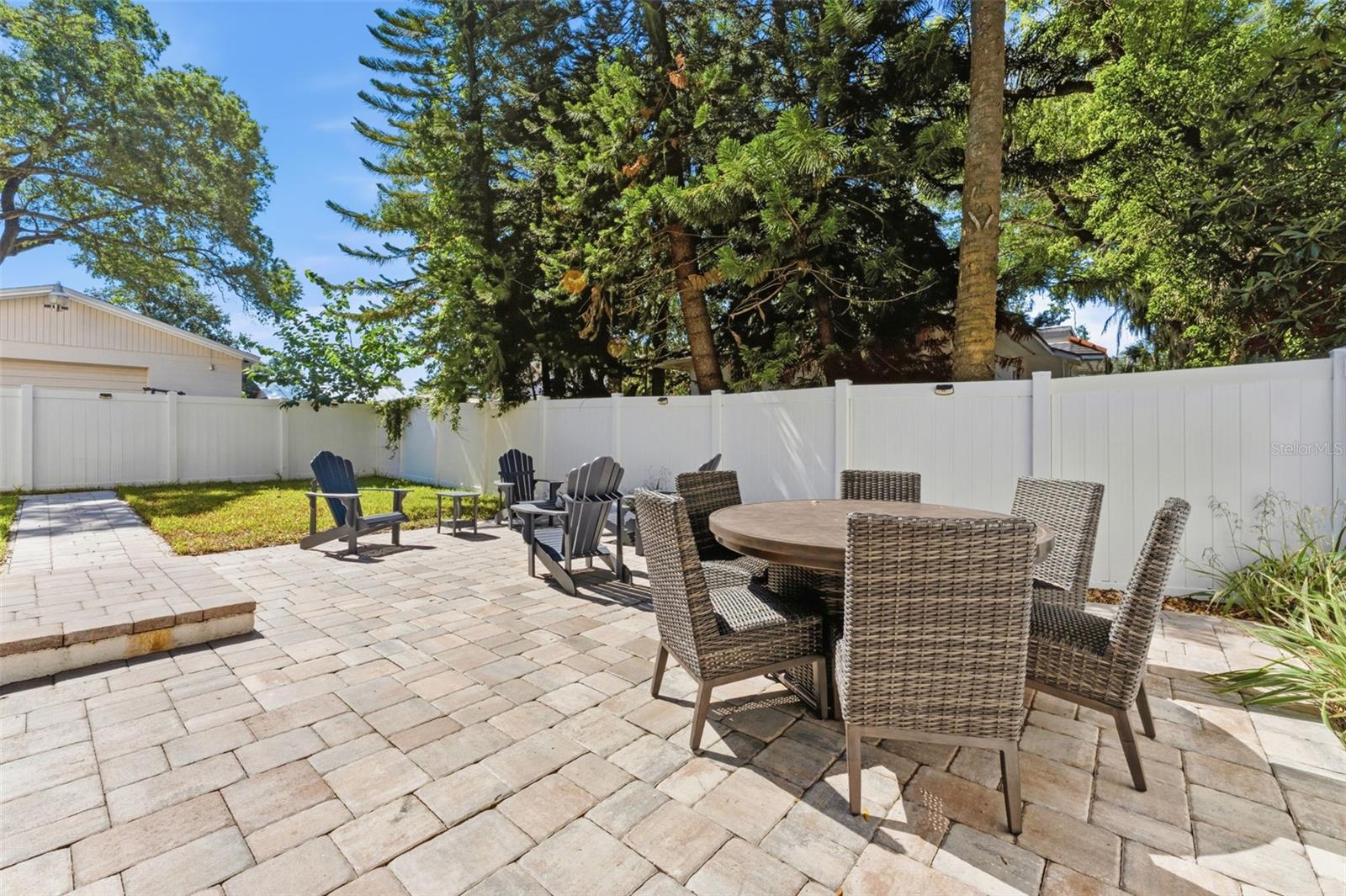 Fully fenced in backyard with a screened-in porch, paver patio for entertaining, professional landscaping, and irrigation system