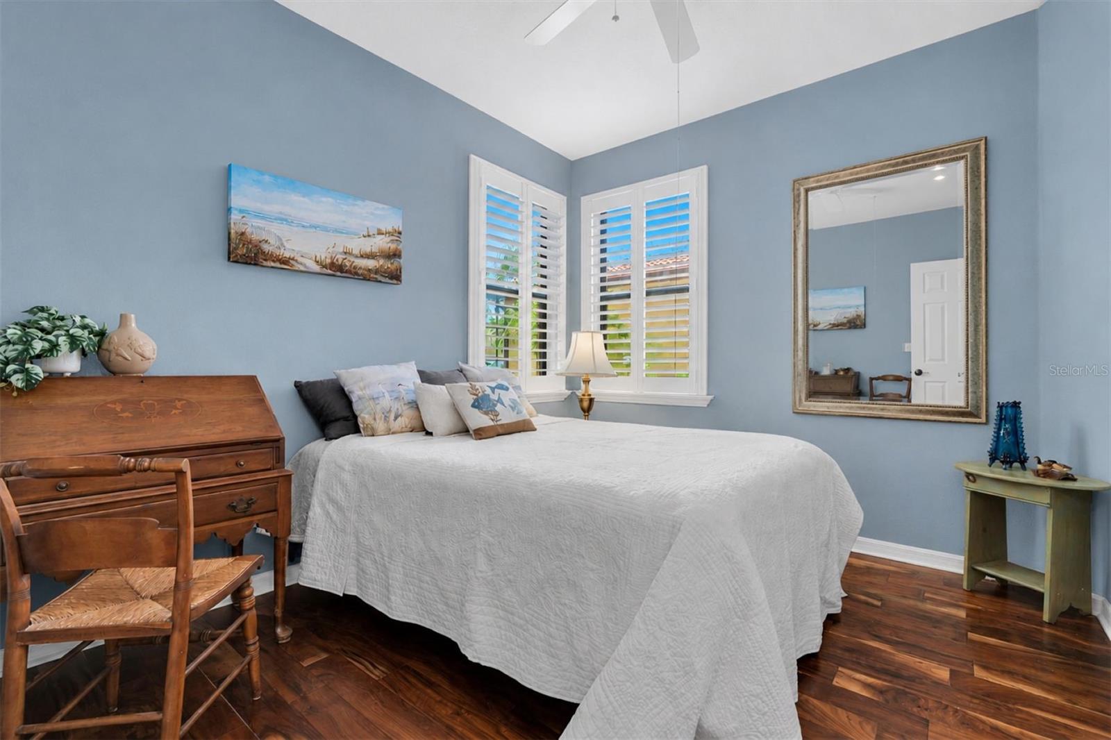 2nd bedroom with coastal style, hardwood floors, plantation shutters, split from master.