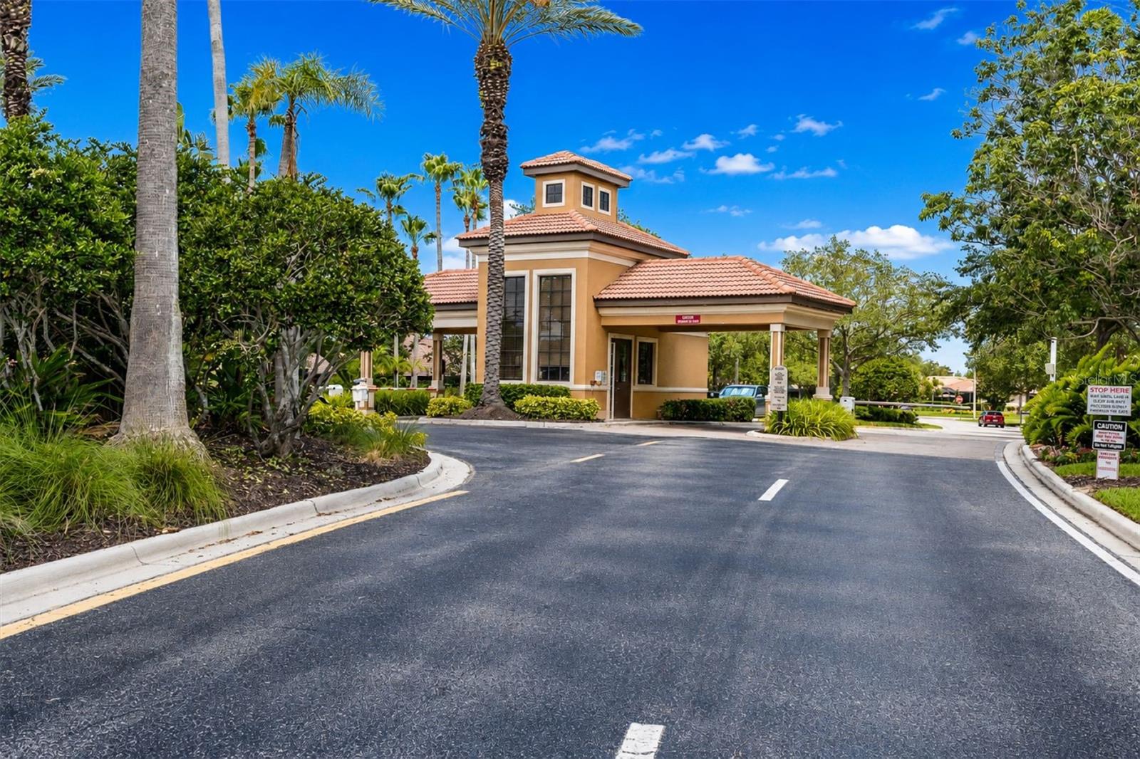 Gated community entrance with tropical landscaping.
