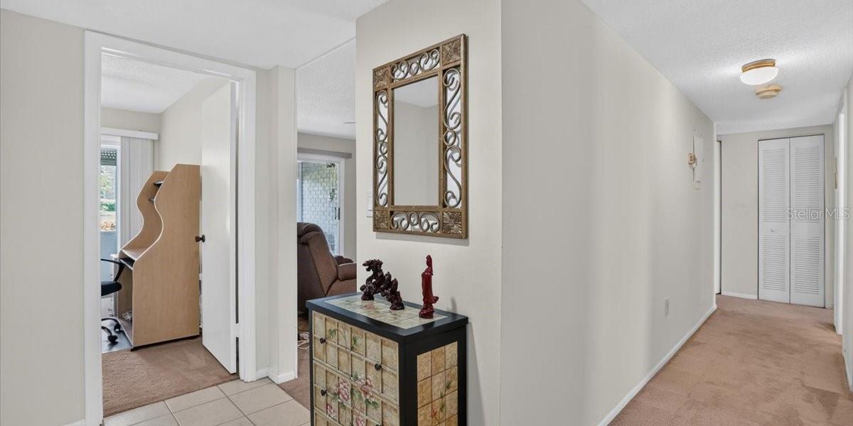 Foyer with hall to 2 larger bedrooms on right, entry to both den and living room on left.