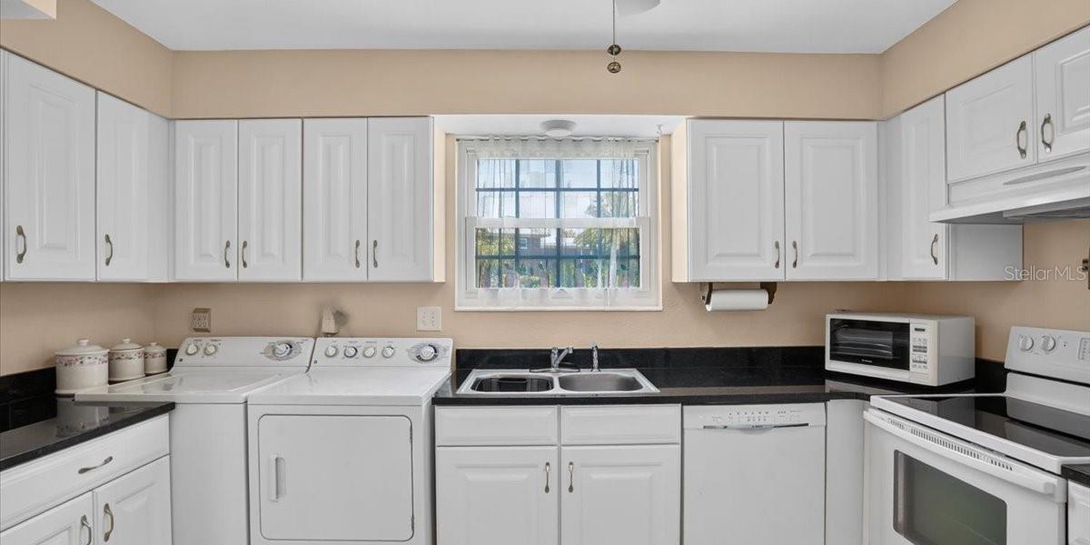 Another view of kitchen. window ove sink looks to green space.