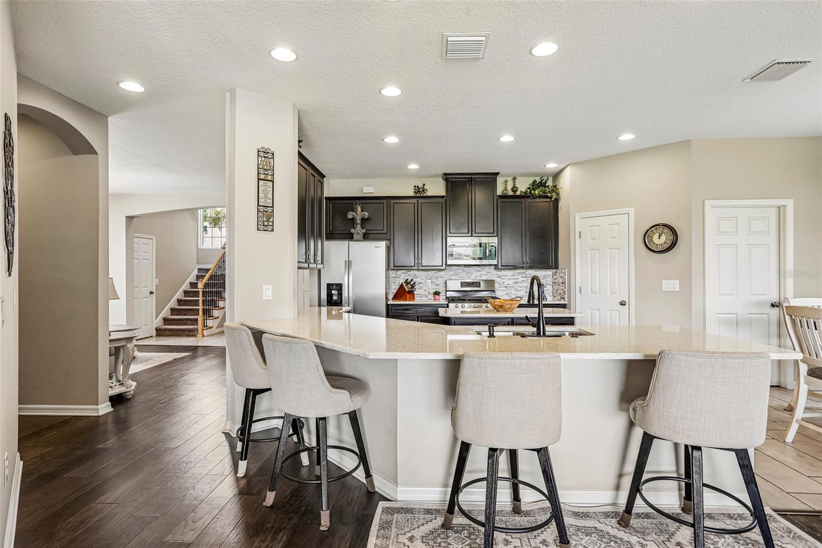 Kitchen area with 42" cabinets, stained appliances, gas range, beautiful backsplash, Island and quartz