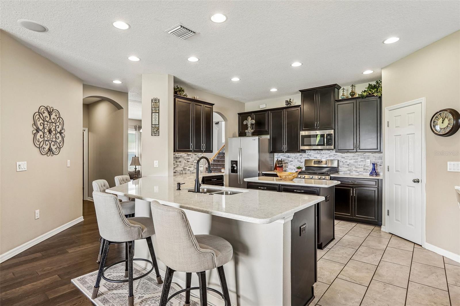 Kitchen area with 42" cabinets, stained appliances, gas range, beautiful backsplash, Island and quartz