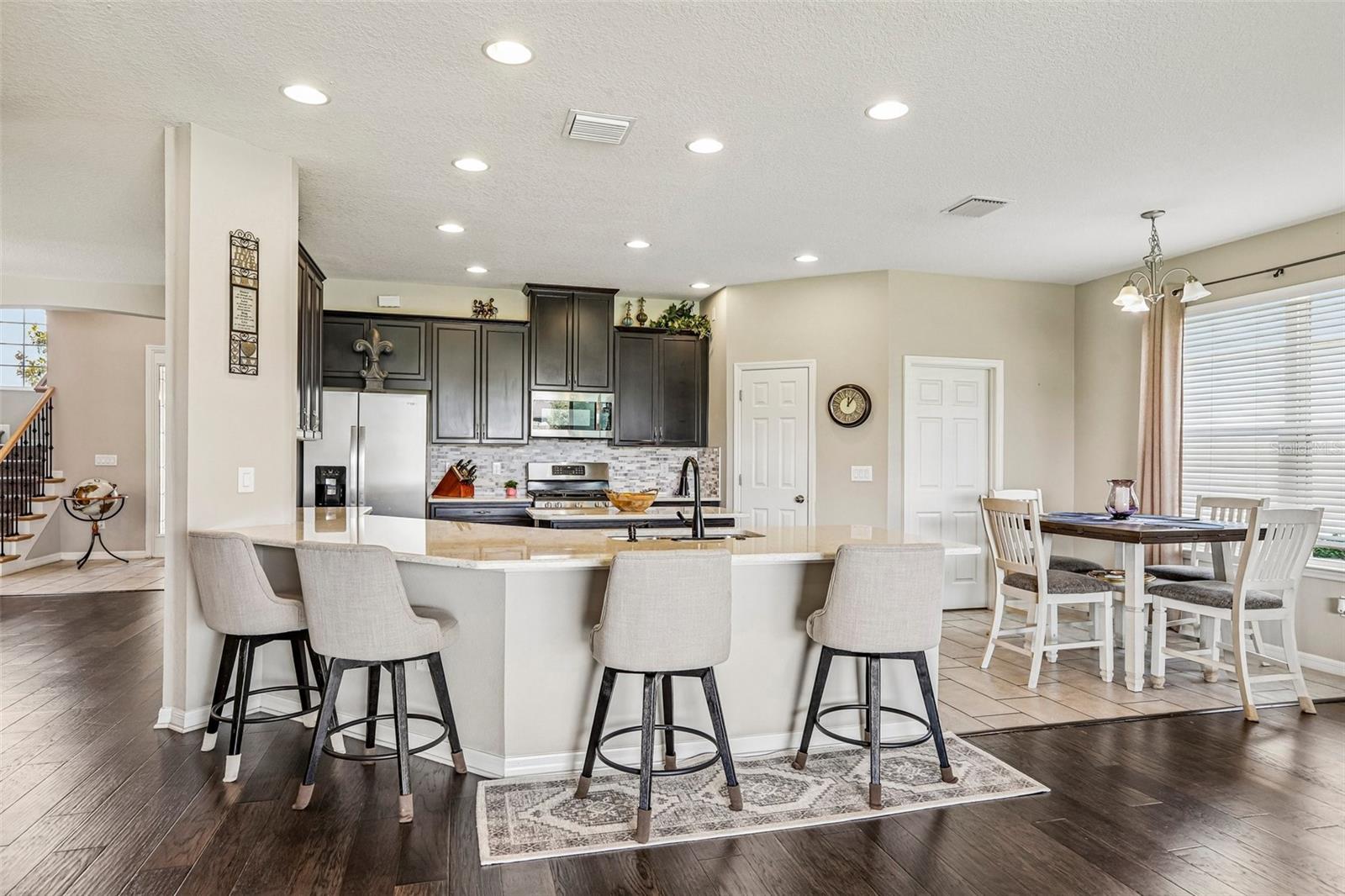Kitchen area with 42" cabinets, stained appliances, gas range, beautiful backsplash, Island and quartz