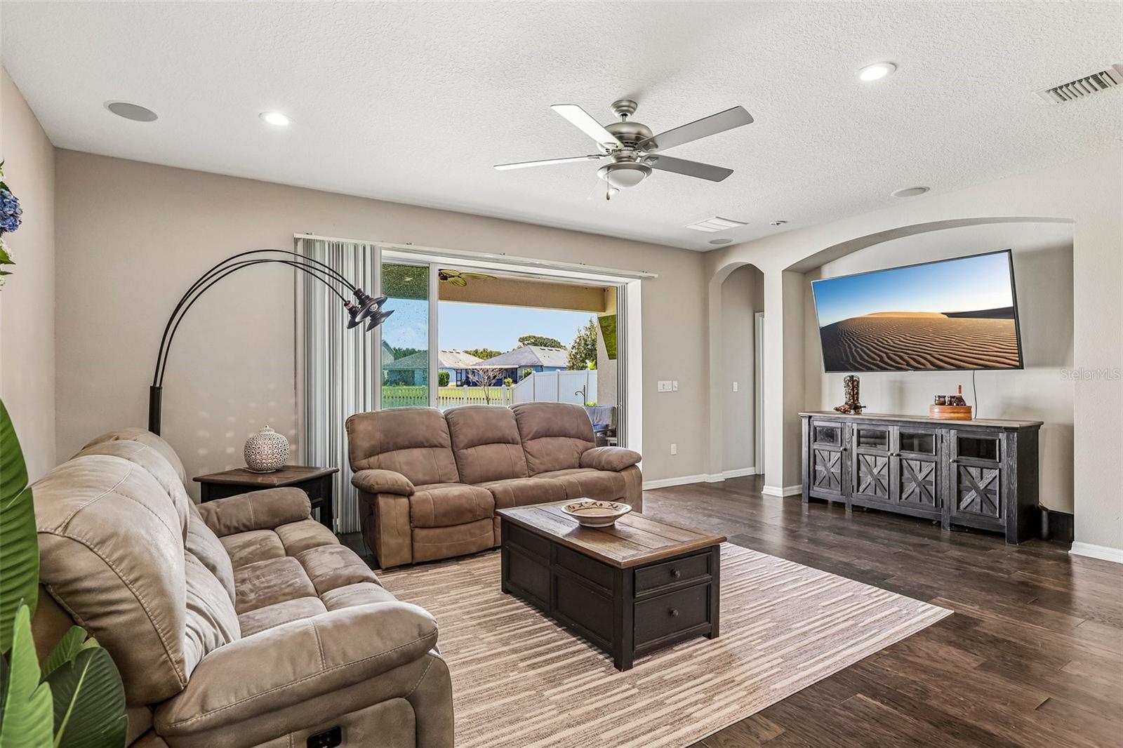 Family Room with beautiful hard wood floors, neutral colors, sliders to the back yard and open to  the kitchen