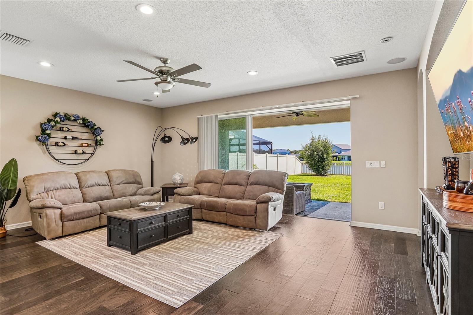 Family Room with beautiful hard wood floors, neutral colors, sliders to the back yard and open to  the kitchen