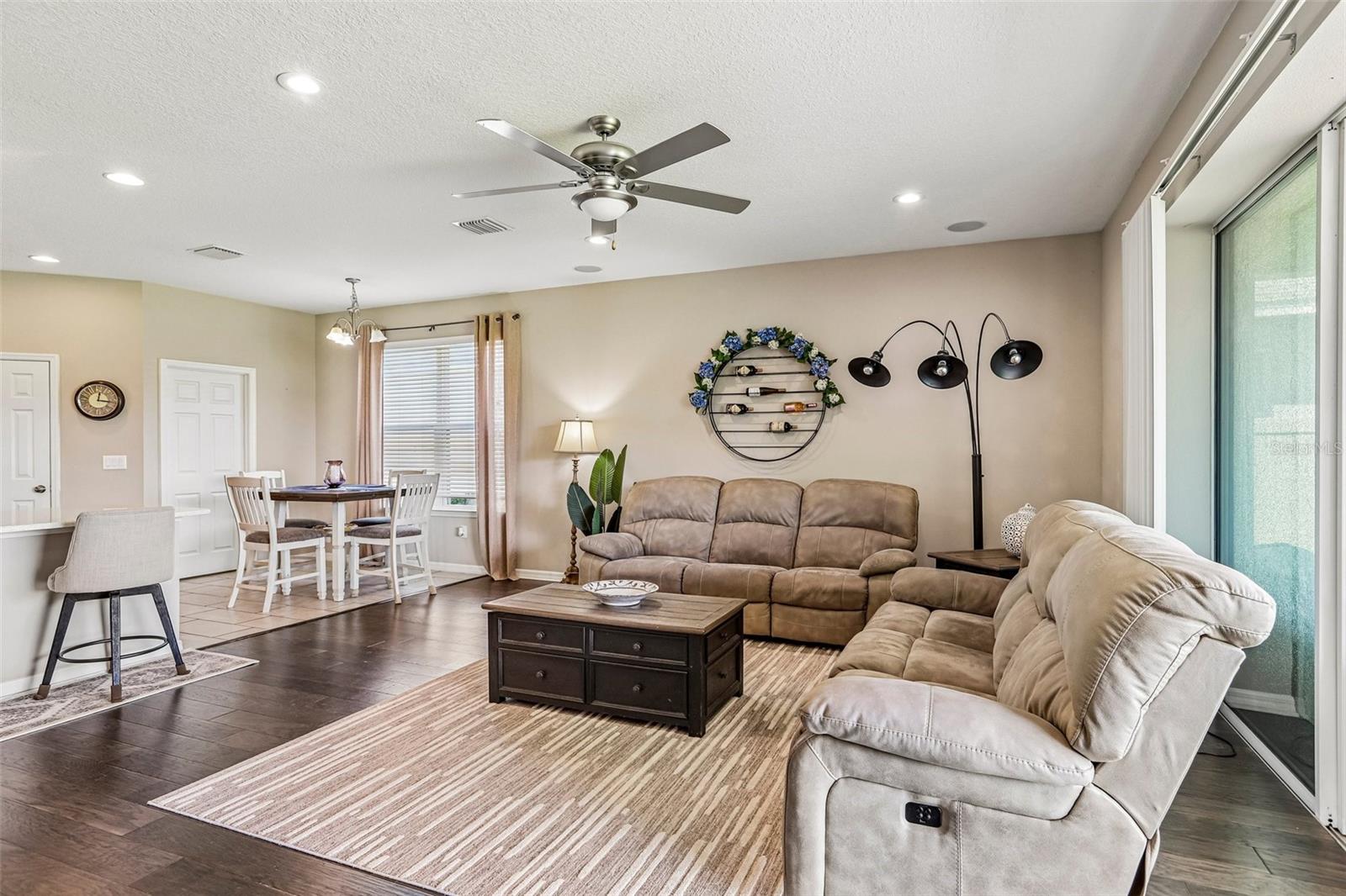 Family Room with beautiful hard wood floors, neutral colors and view to dinette area and kitchen.
