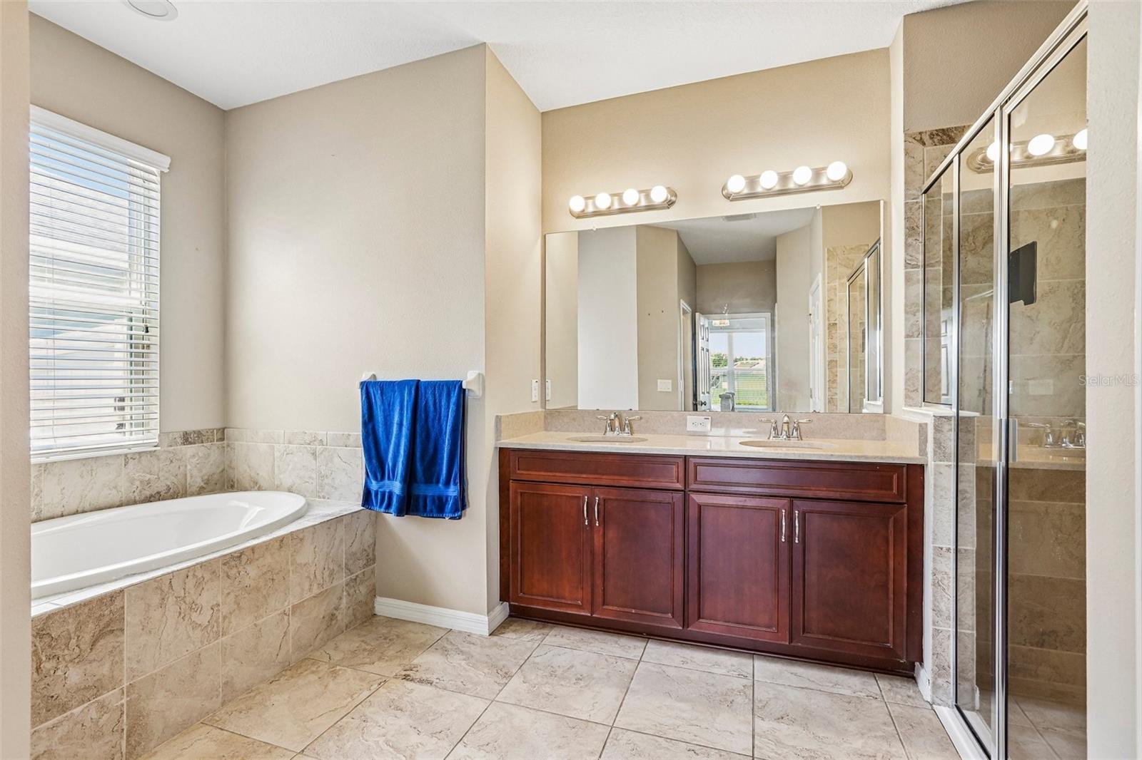 Primary Bathroom with dual vanity, soaking tub, walk in shower and 2 walk in closets