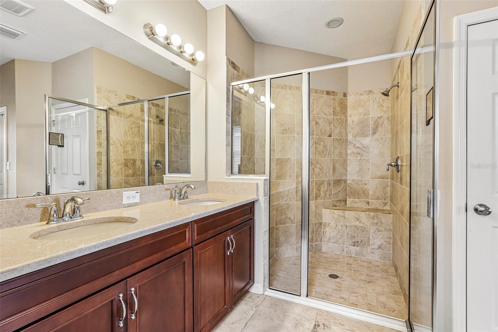 Primary Bathroom with dual vanity, soaking tub, walk in shower and 2 walk in closets