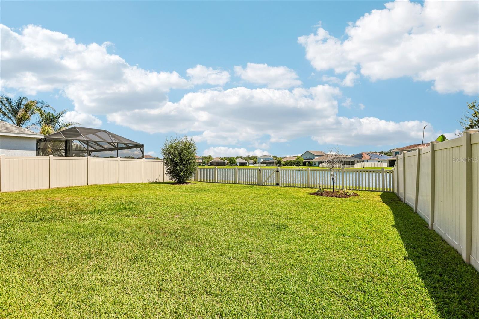 Back yard with vinyl fencing and view to pond